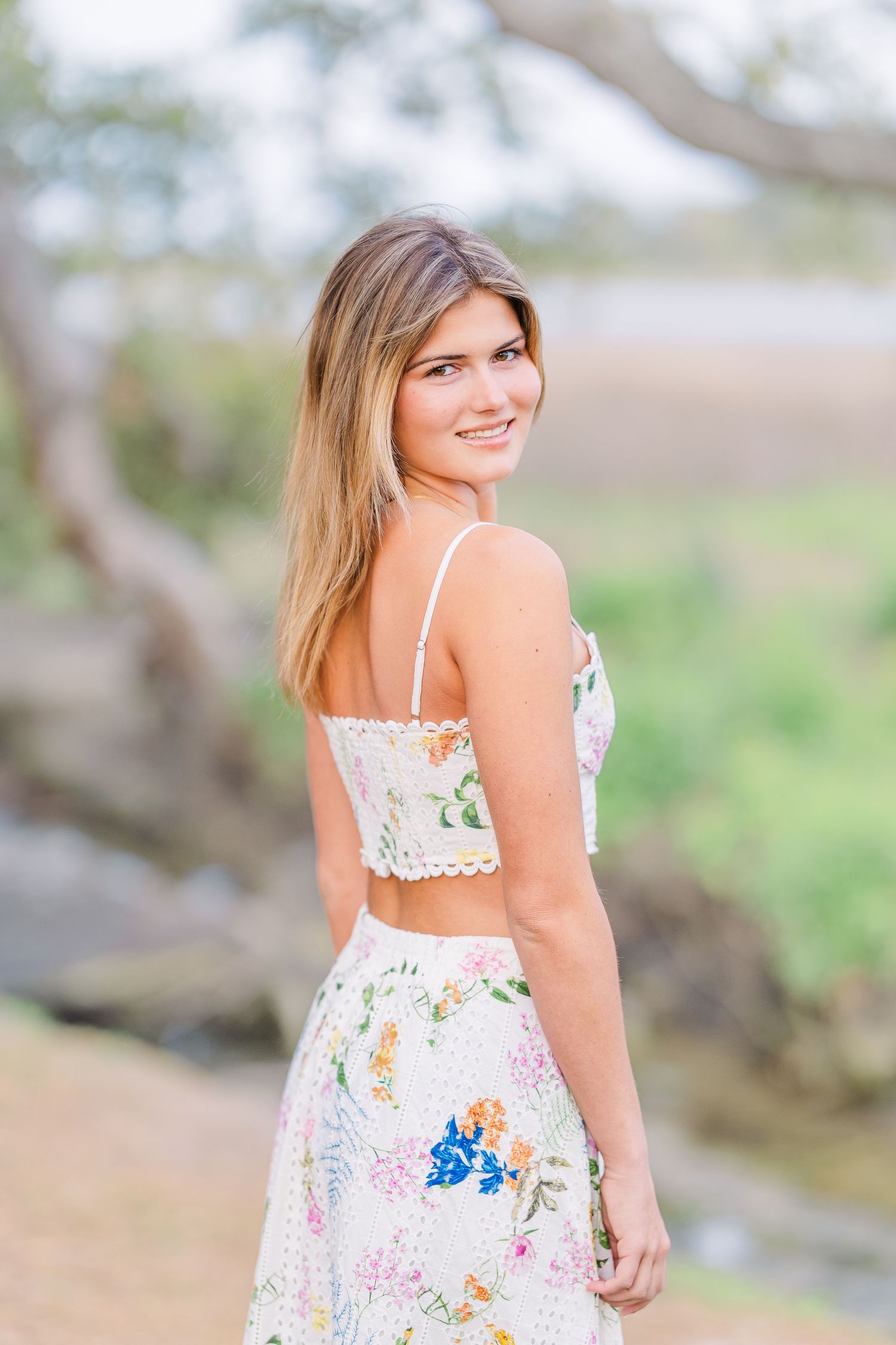 Floral sundress with lace trim details photographed in outdoor garden setting.