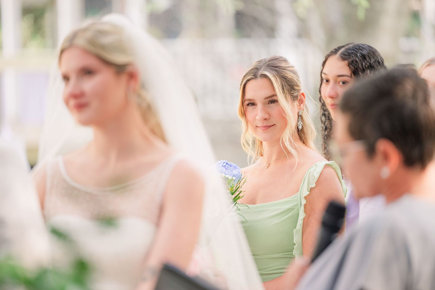 Wedding party members in light green dresses and white suits gather outdoors for a celebration wedding groom bride wilmington photographer