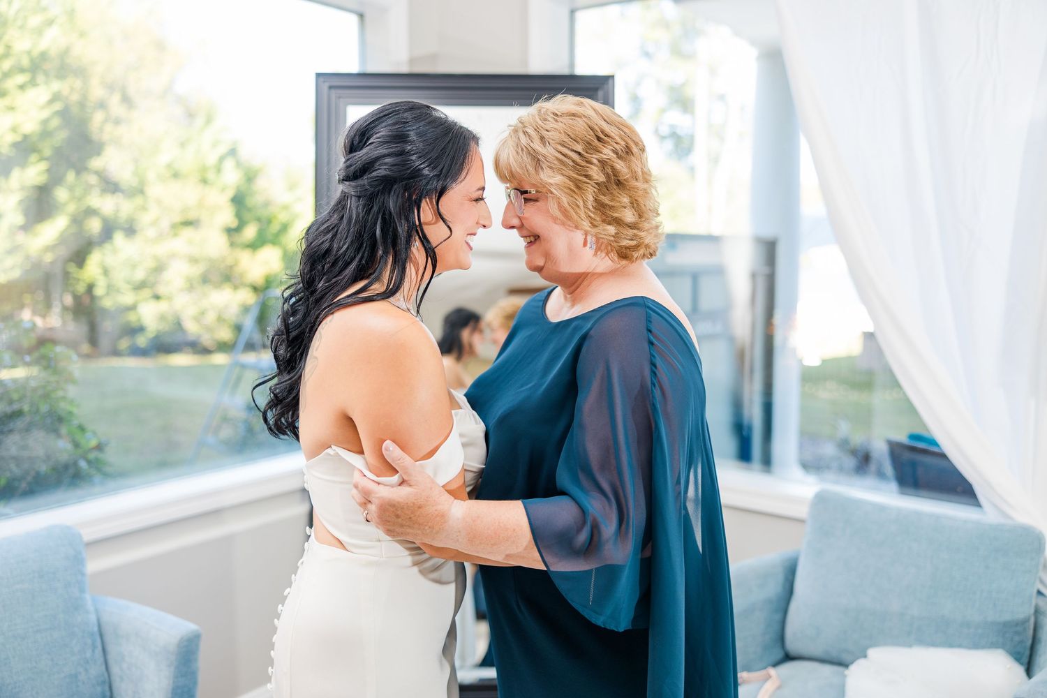An emotional moment shared between a bride in white and woman in navy blue on a wedding day wedding groom bride lake Gaston photographer l