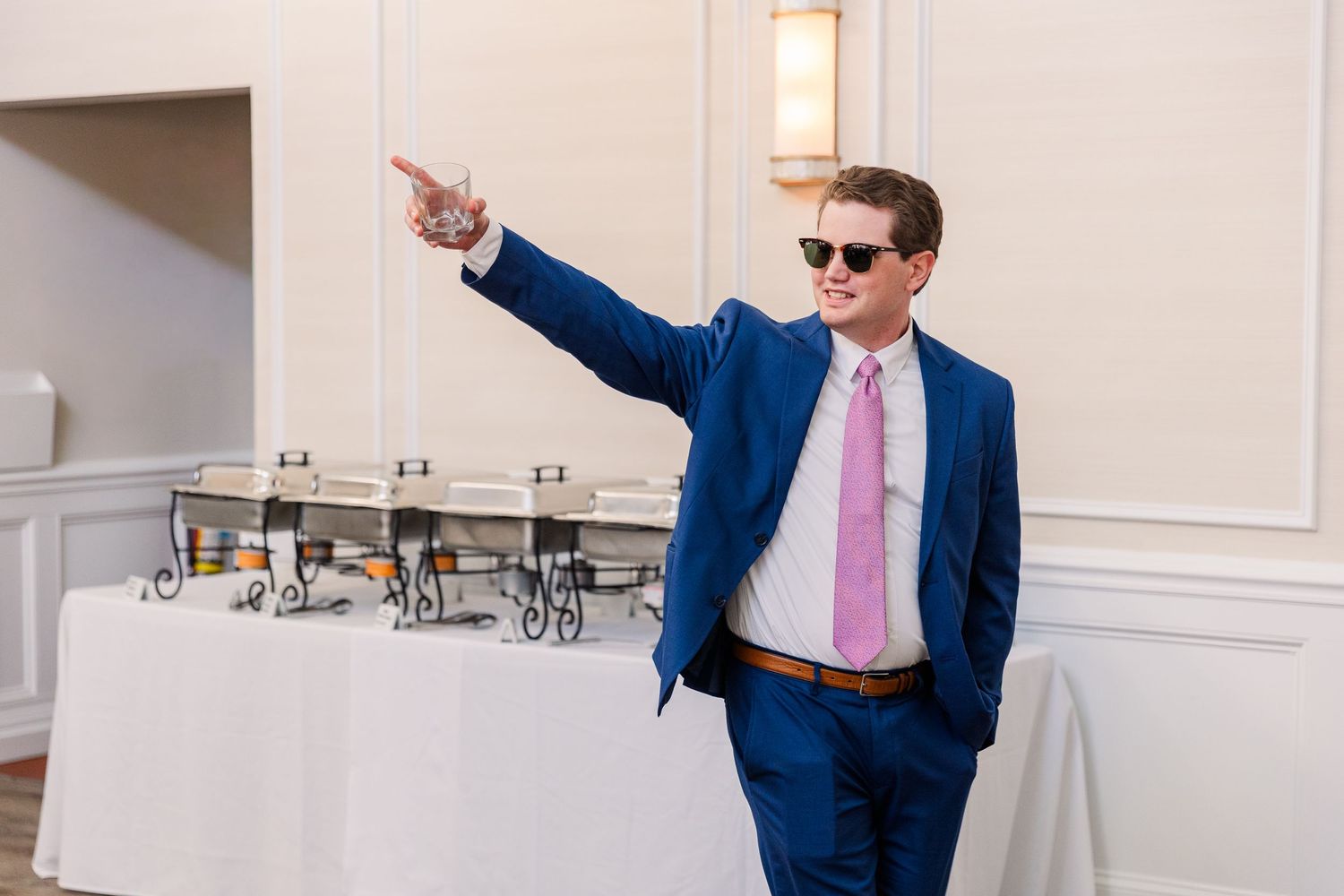 Celebratory dance moves by wedding party members in a bright indoor reception space.
