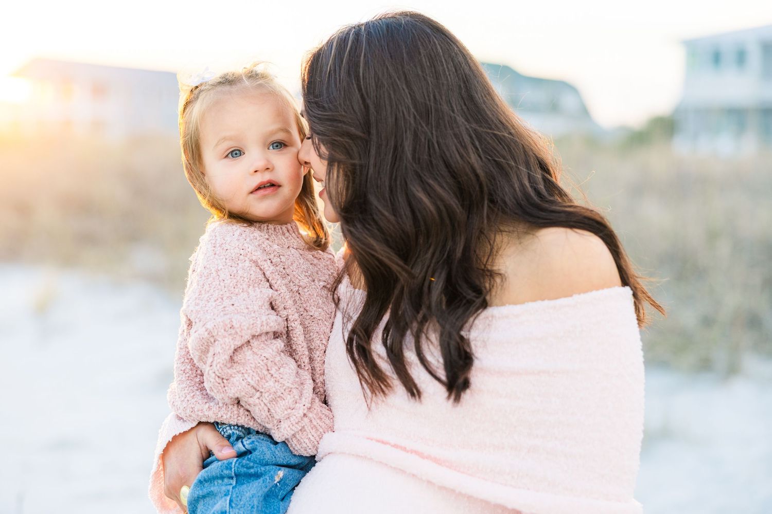 Natural light beach photography of parent and child in matching pink tops.
