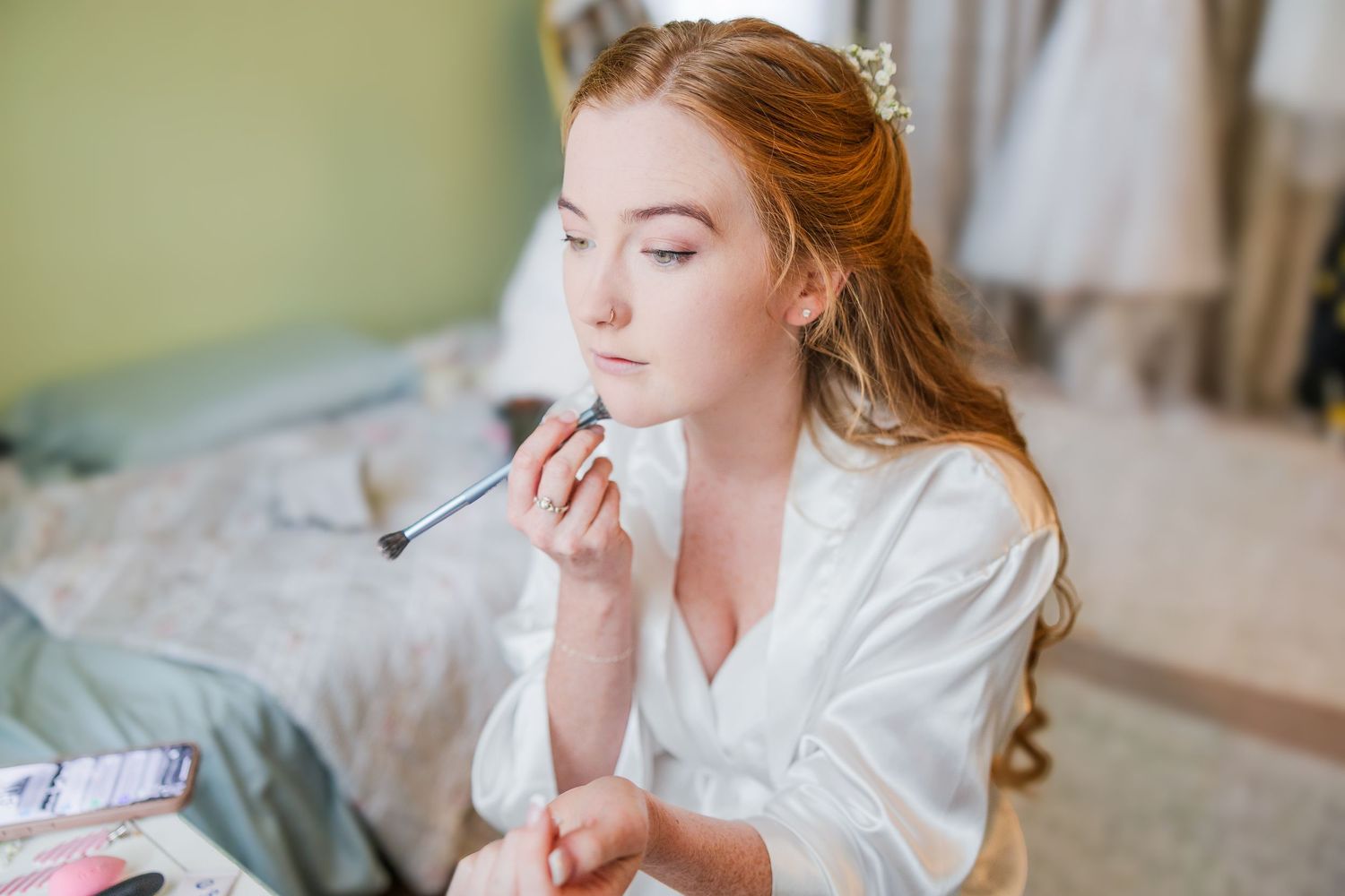 Getting ready scene with makeup application in a soft green room wedding groom bride wilmington North Carolina photographer light and airy