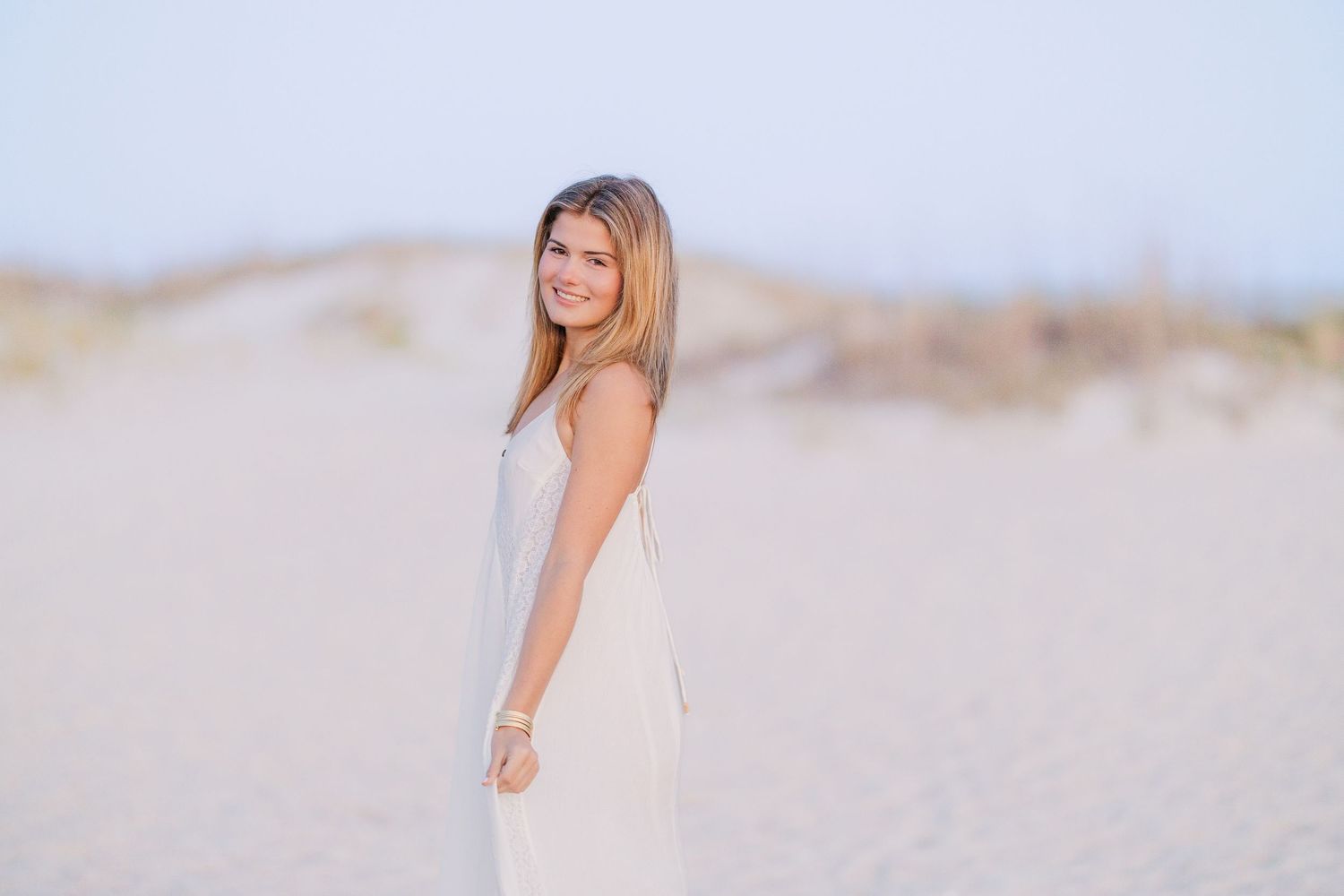 Minimalist beach portraits with soft lighting and flowing white fabric.