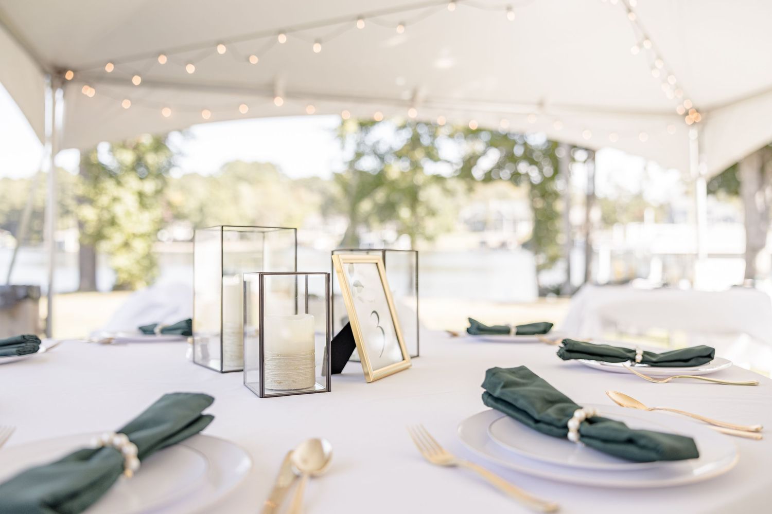 Wedding reception tent setup with string lights and elegant table settings wedding groom bride lake Gaston photographer light airy
