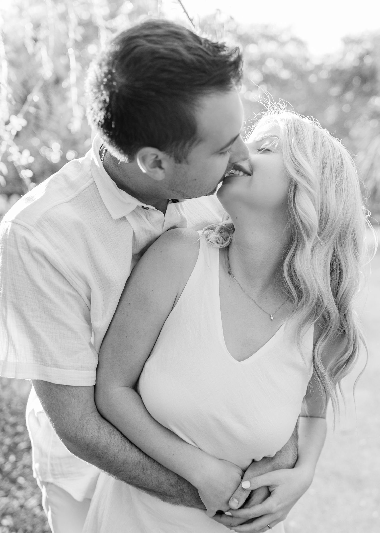An intimate black and white portrait of a couple sharing a romantic moment.