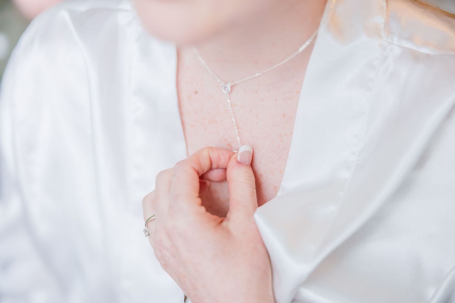Close-up of delicate white satin fabric with pearl details wedding groom bride wilmington North Carolina photographer light and airy