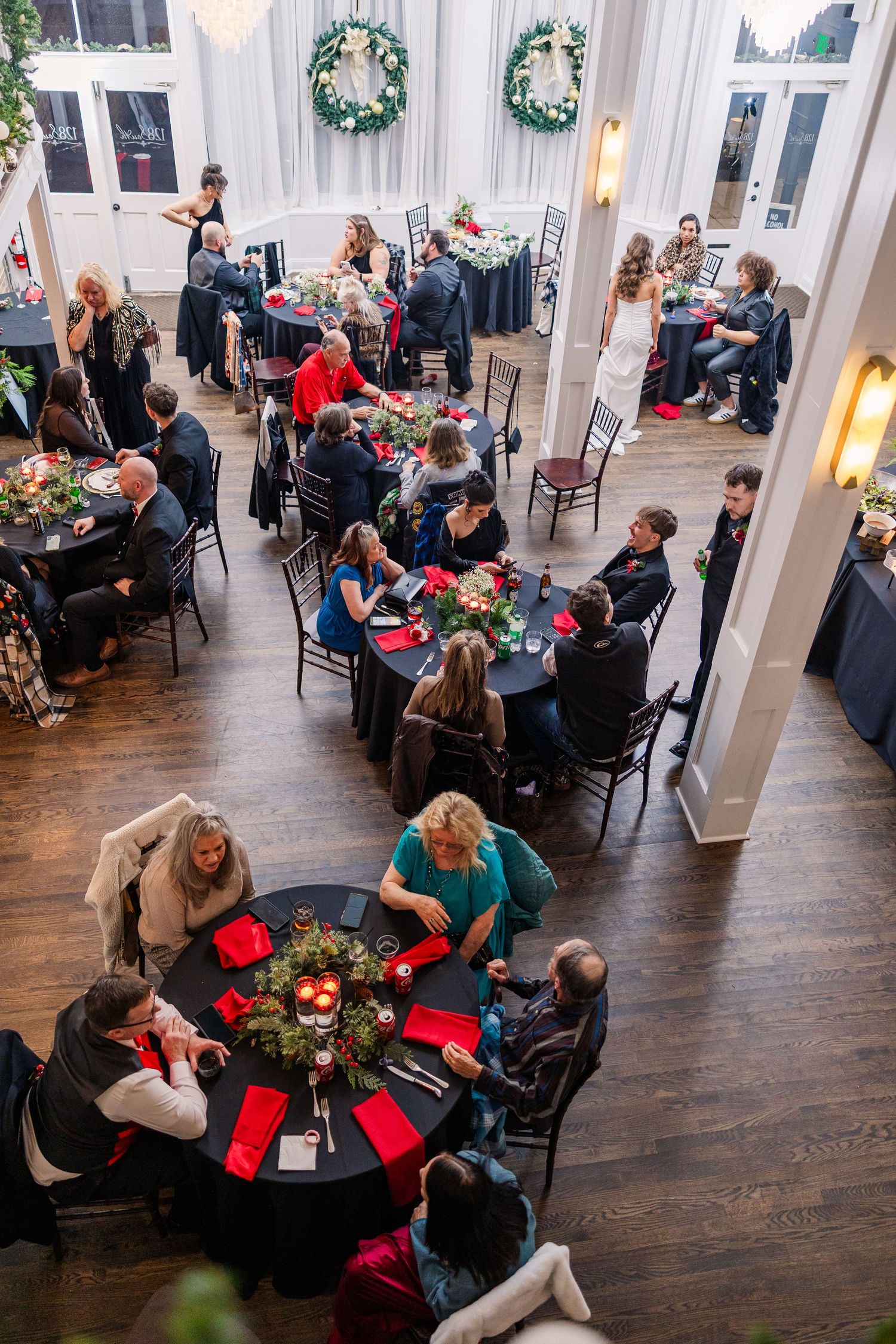 Overhead view of wedding reception with guests seated at round tables decorated with floral centerpieces wedding groom bride wilmington Nort