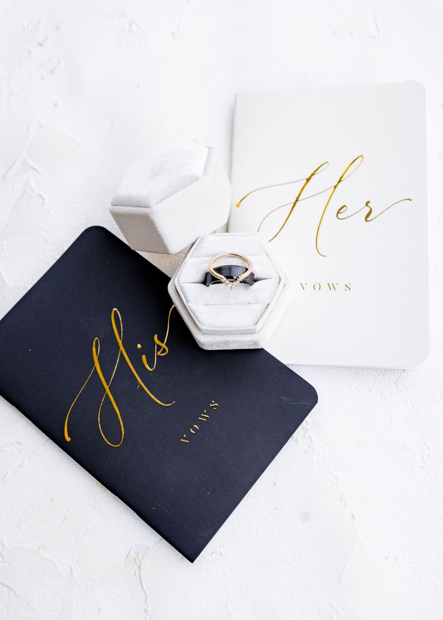 Black wedding cards with gold calligraphy displayed on white surface wedding groom bride lake Gaston photographer light airy