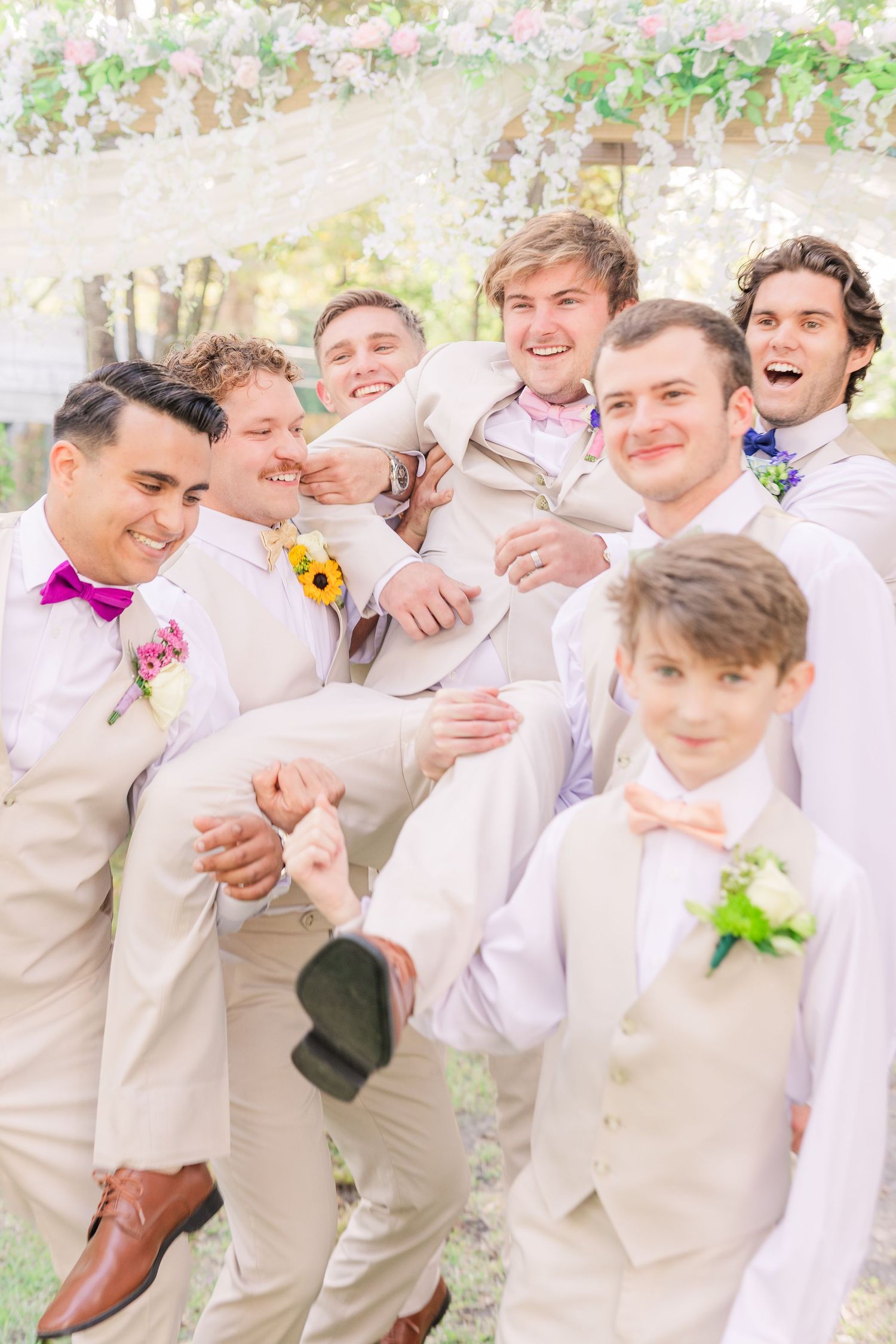 Groomsmen laugh and embrace during candid wedding party photo session wedding groom bride wilmington photographer light and airy classic