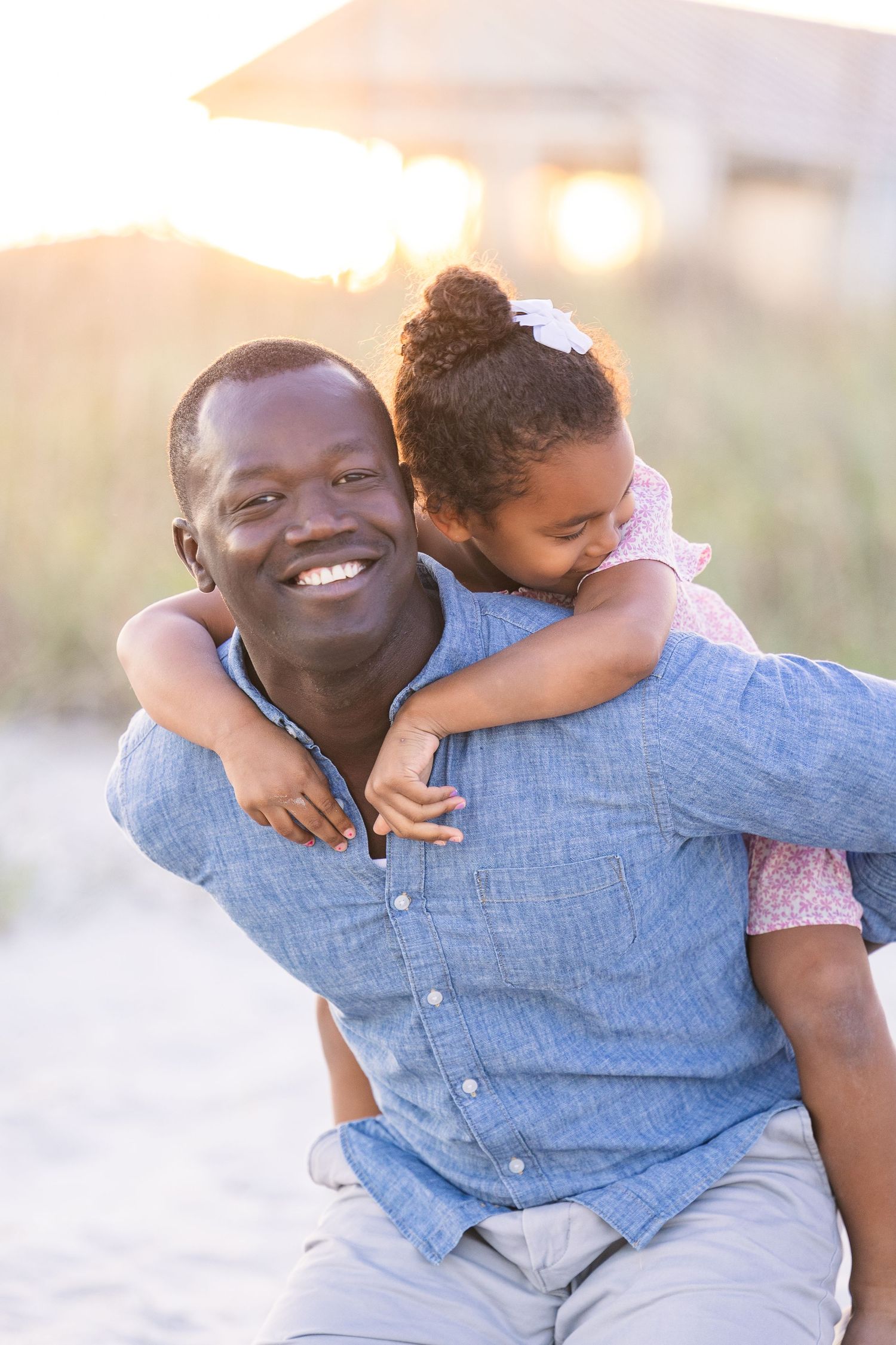 Joyful piggyback ride on the beach during golden hour.