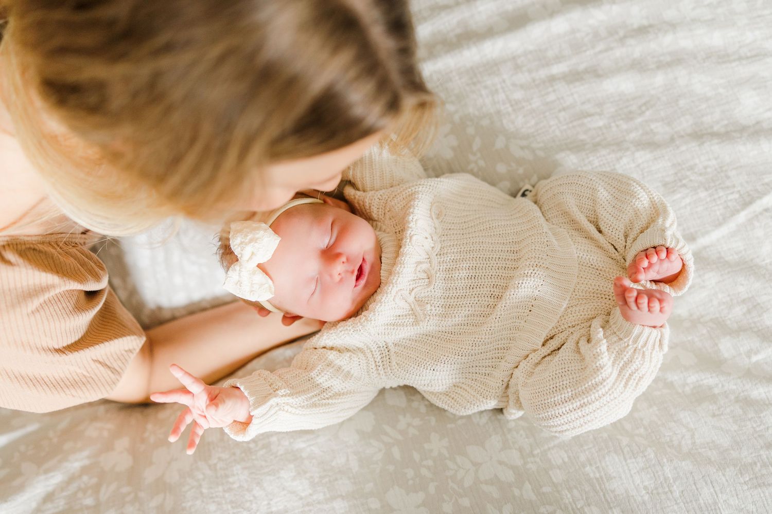 Artistic close-up of baby details on white textured fabric.