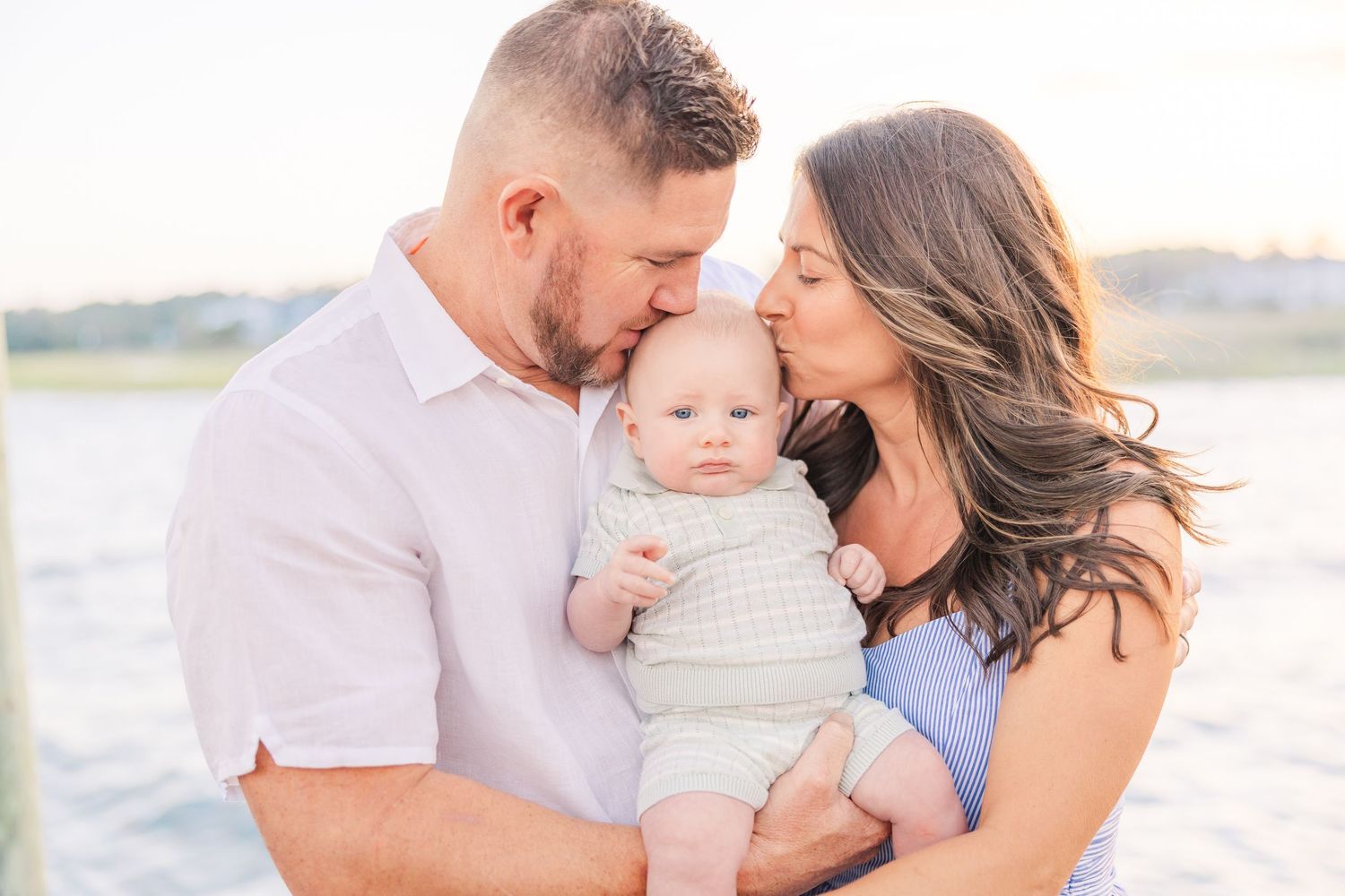 Intimate family portraits captured on wooden deck at golden hour.