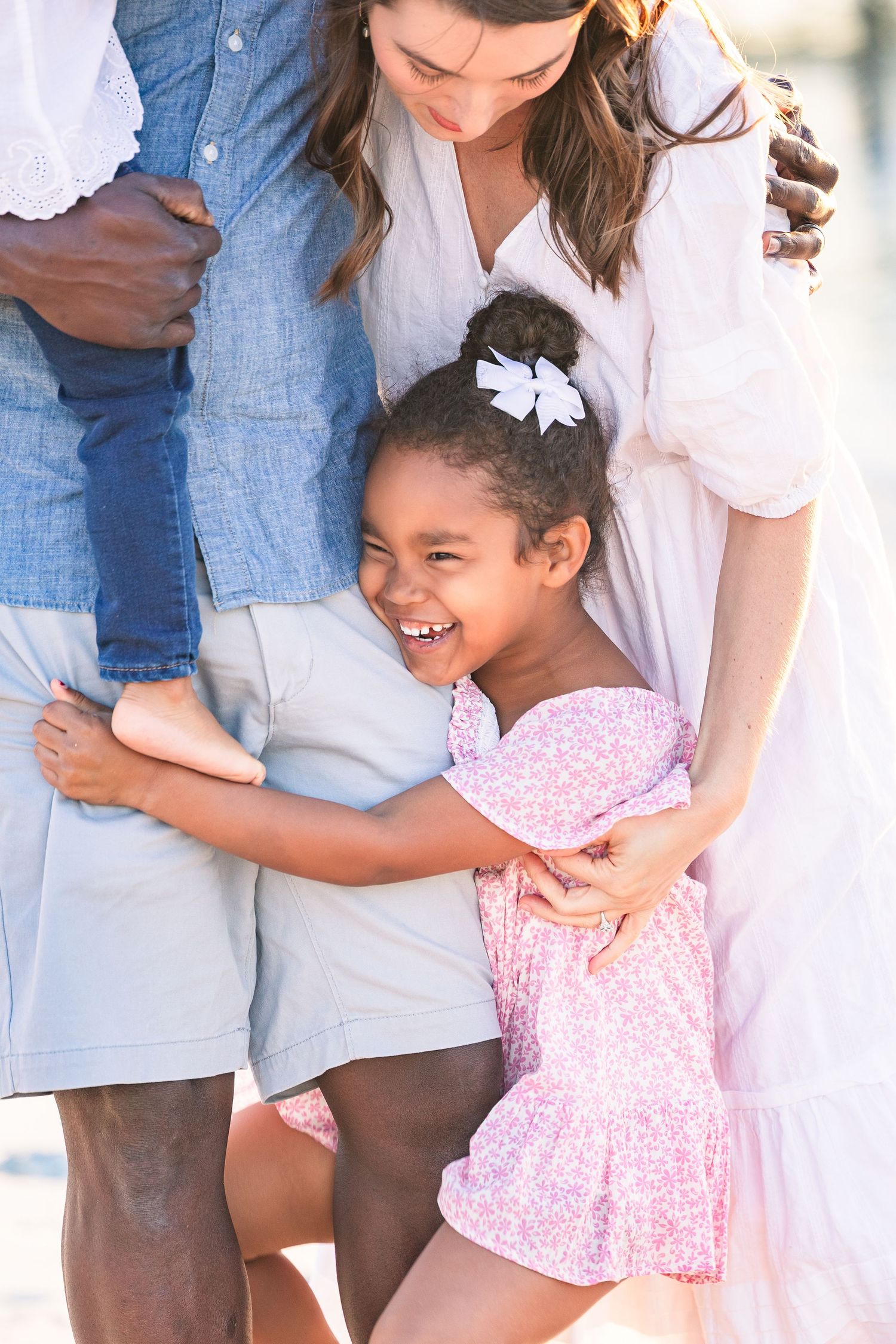 Close-up shots of family members hugging and laughing together outdoors.