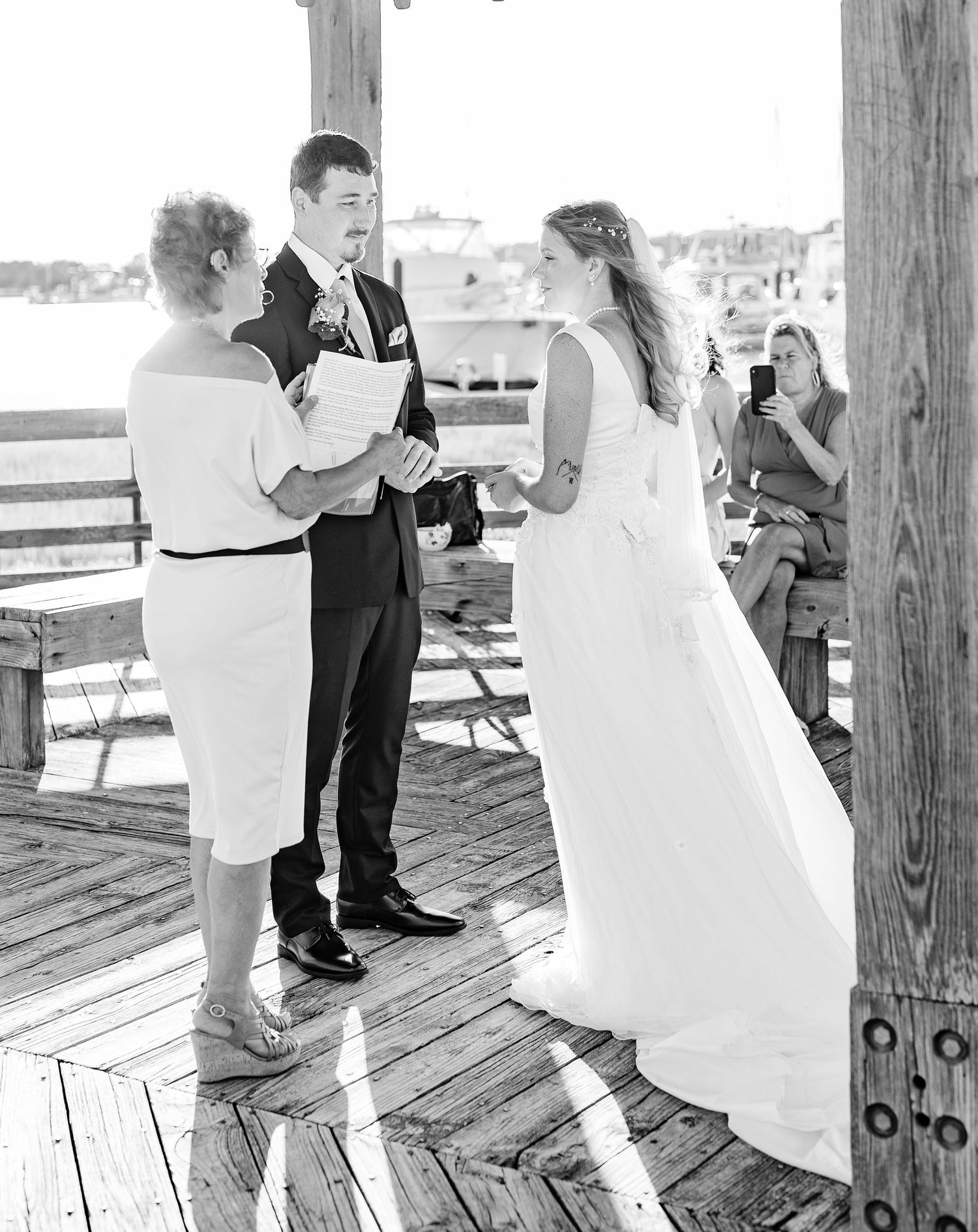 Black and white wedding photography sequence on wooden boardwalk by the sea southport elopement wedding bride groom light and airy classic