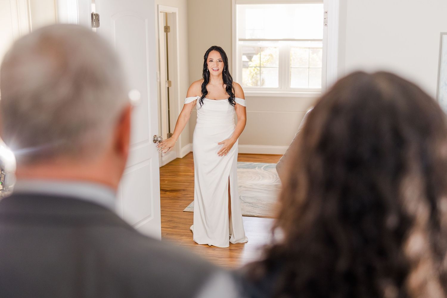 Bride in elegant white gown makes her entrance in a sunlit room wedding groom bride lake Gaston photographer light airy