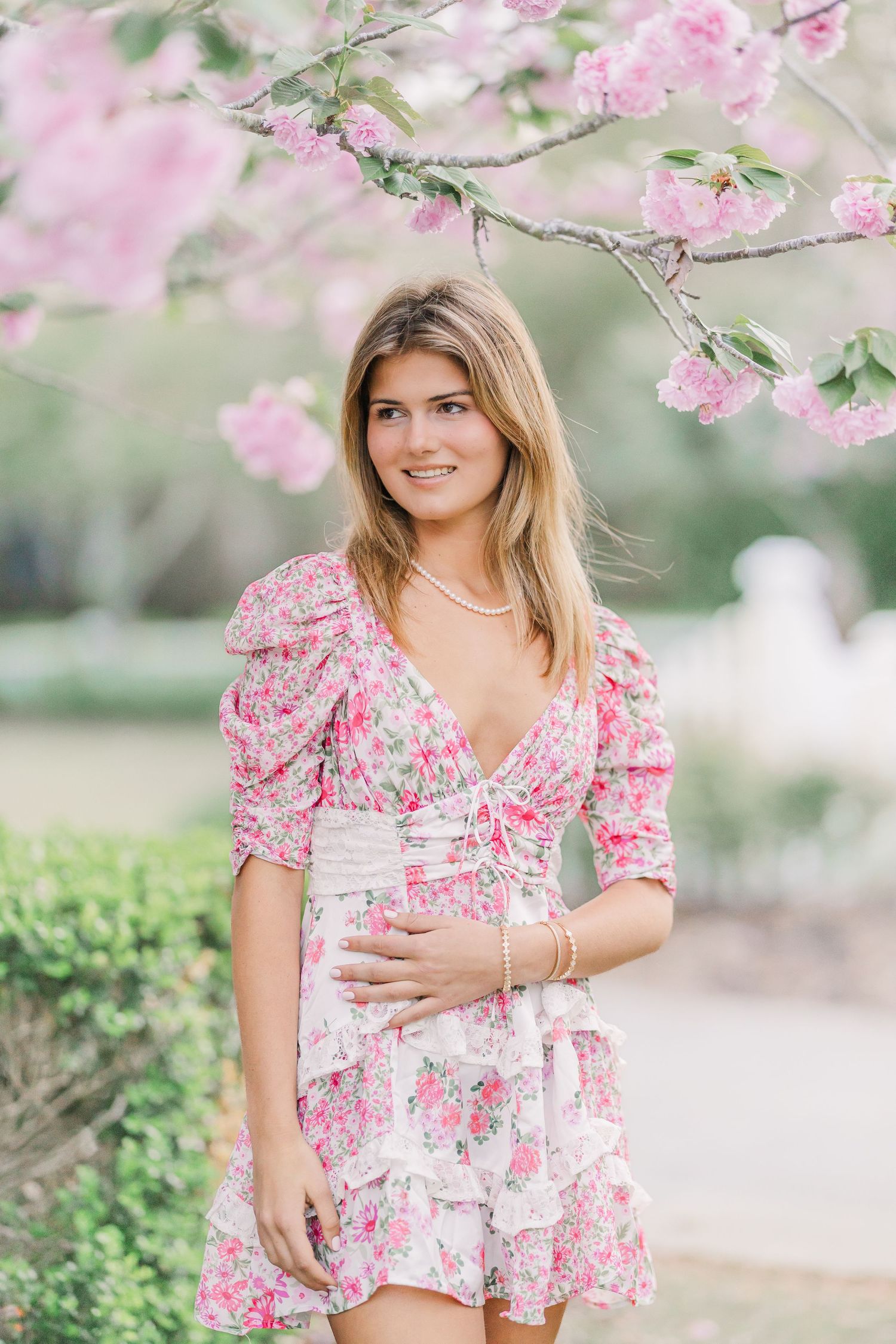 Pink floral dress photographed under blooming cherry blossom trees.