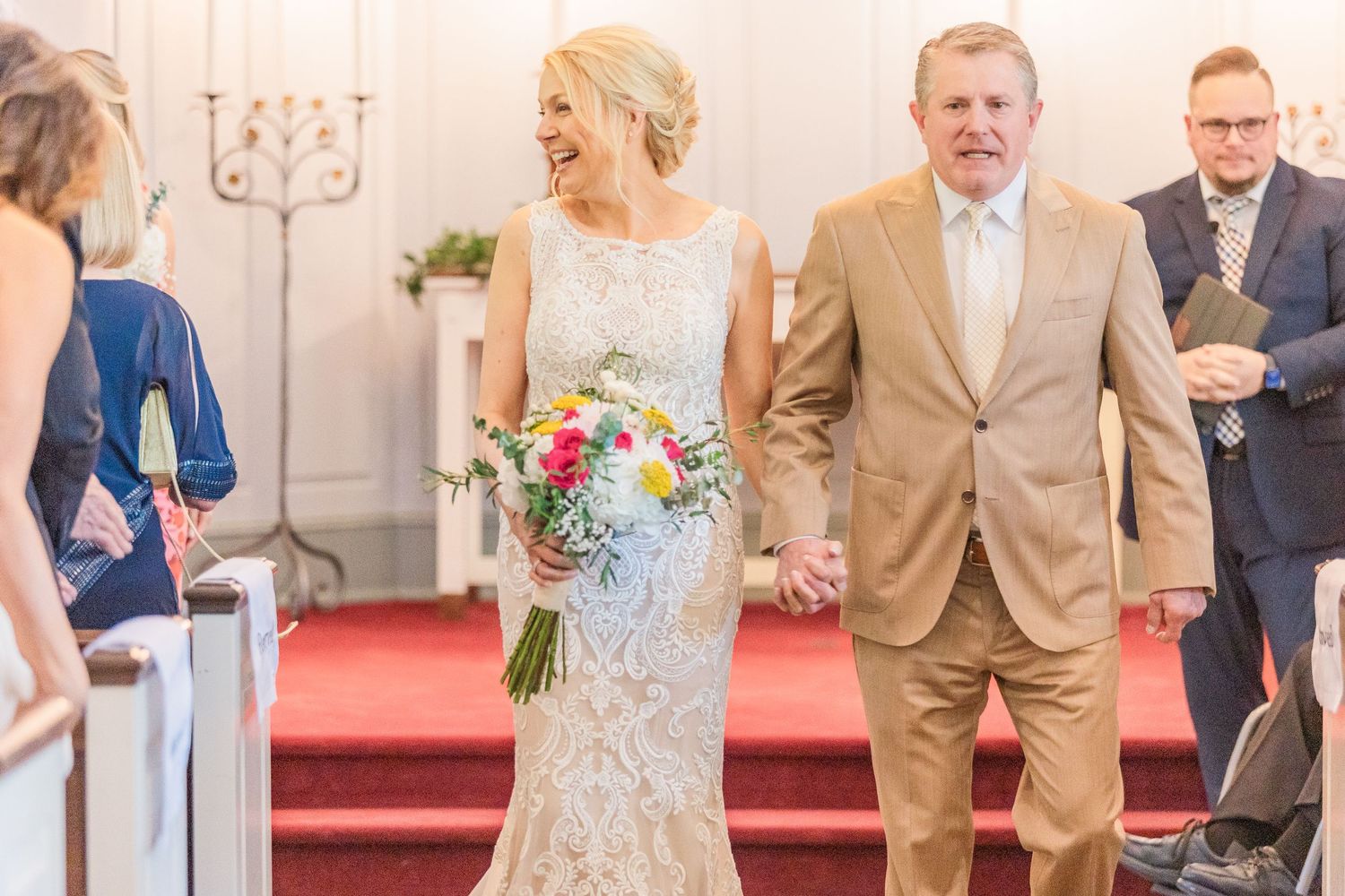 Wedding ceremony candid moments captured in bright church setting with decorative details.