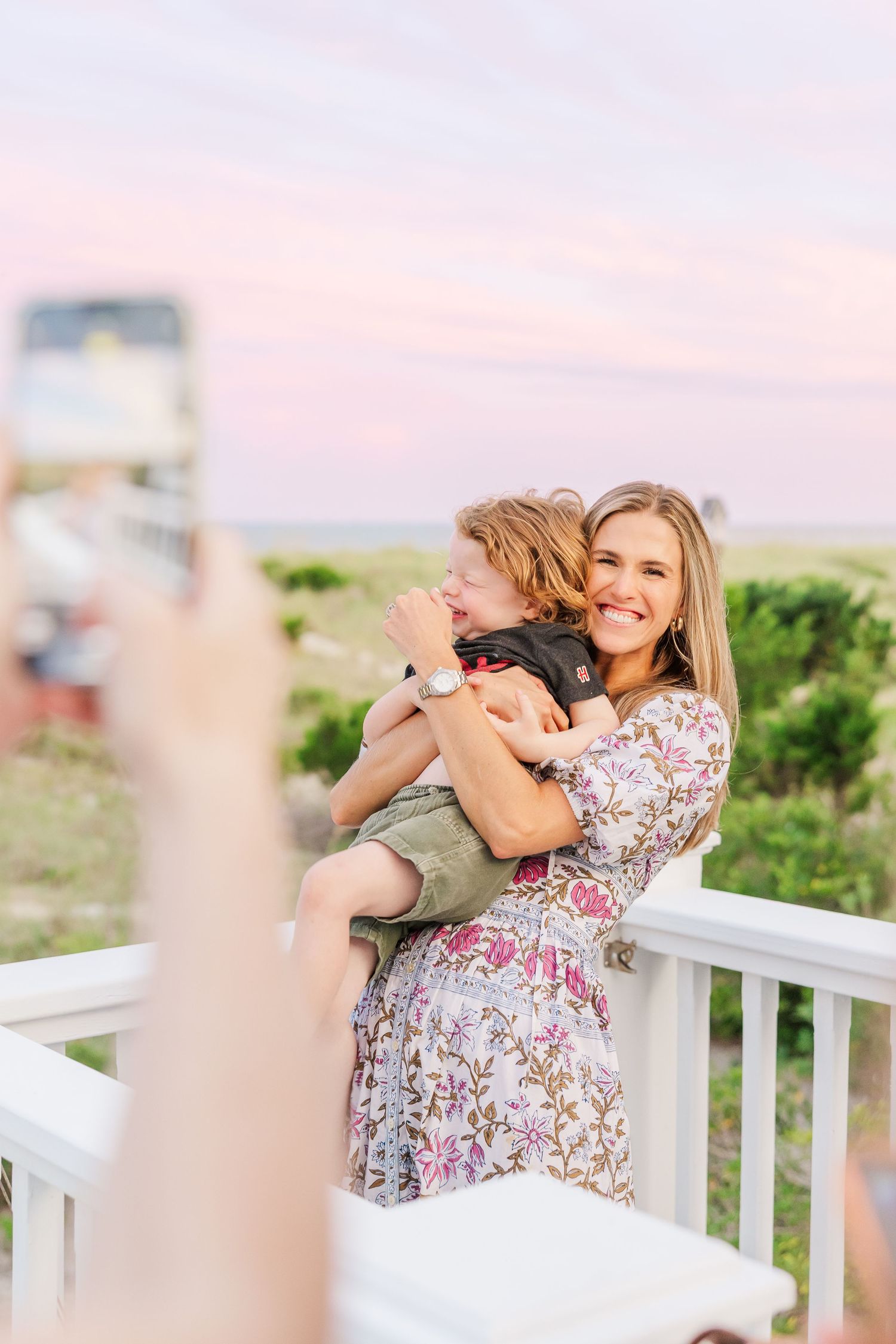 A tender moment captured on a beach house deck during golden hour.