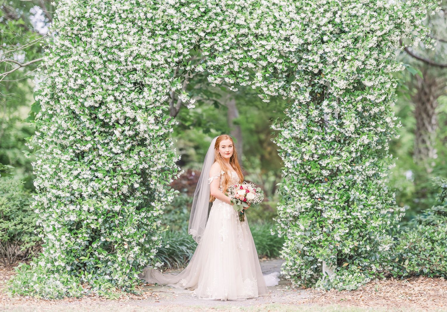 Romantic garden wedding photos with white flowering trees creating a dreamy spring backdrop in harborway gardens in Wrightsville Beach, nc