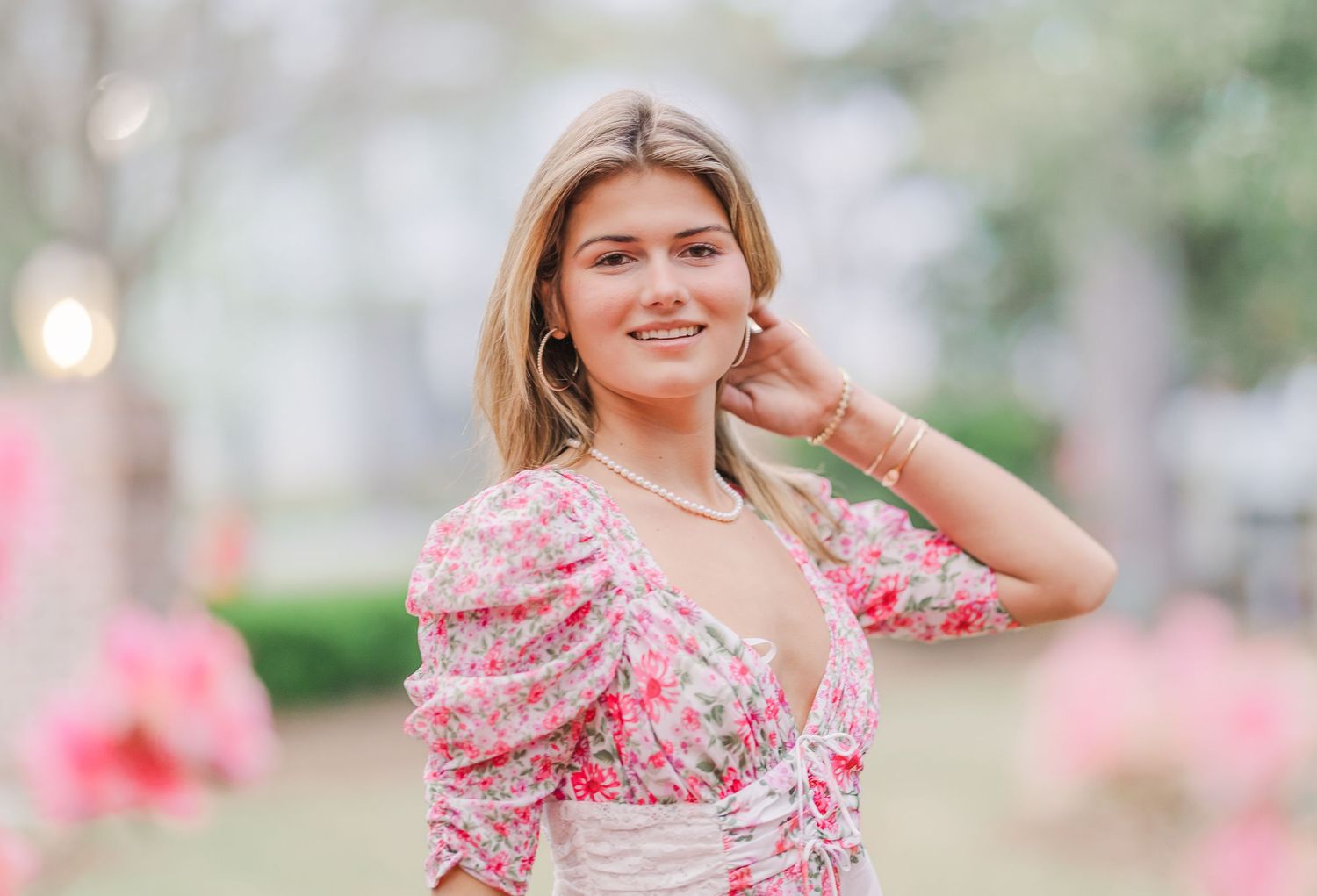 Pink floral dress captured in romantic garden setting with soft lighting.