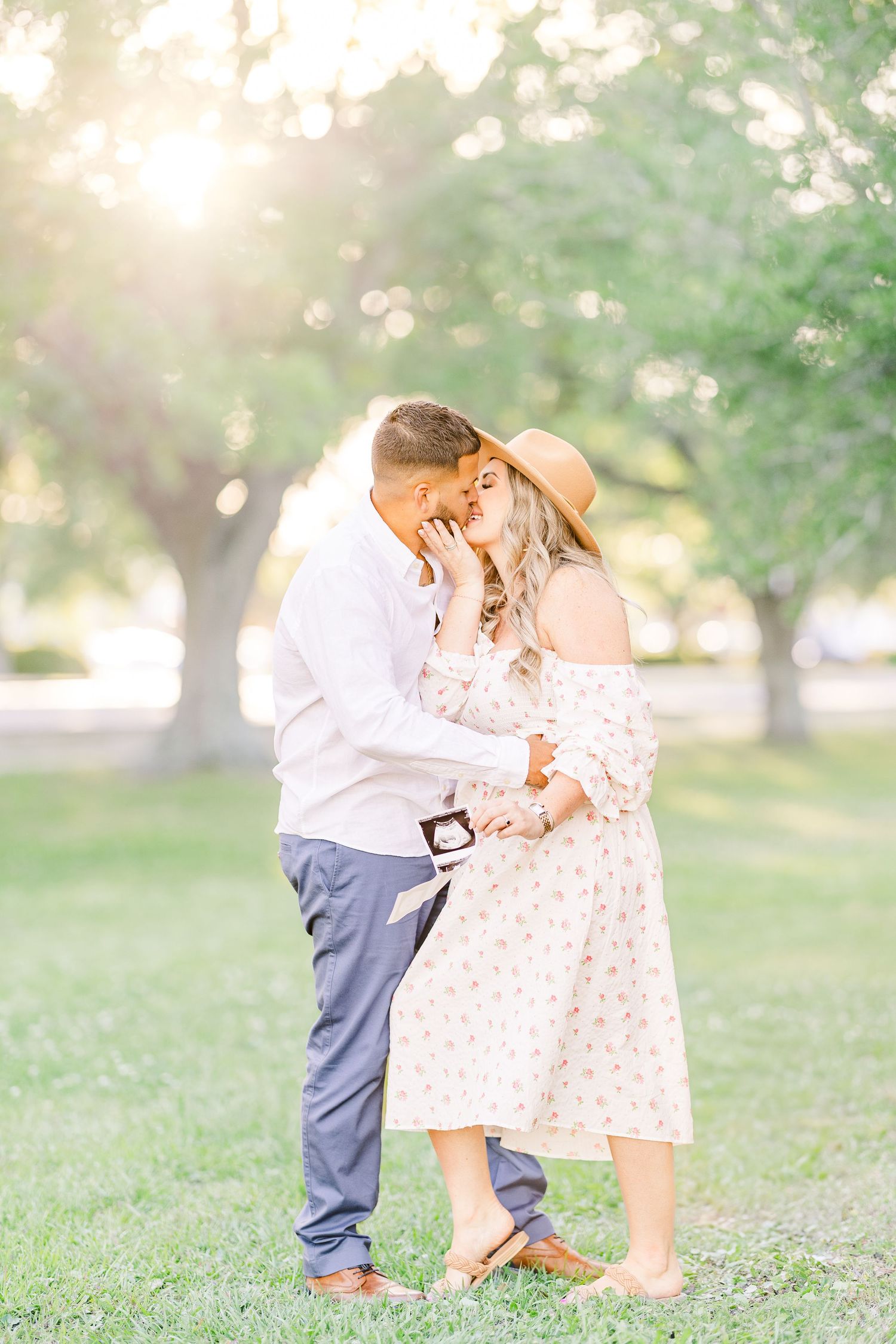 A romantic outdoor photo session in a sun-drenched park with soft bokeh lighting effects.