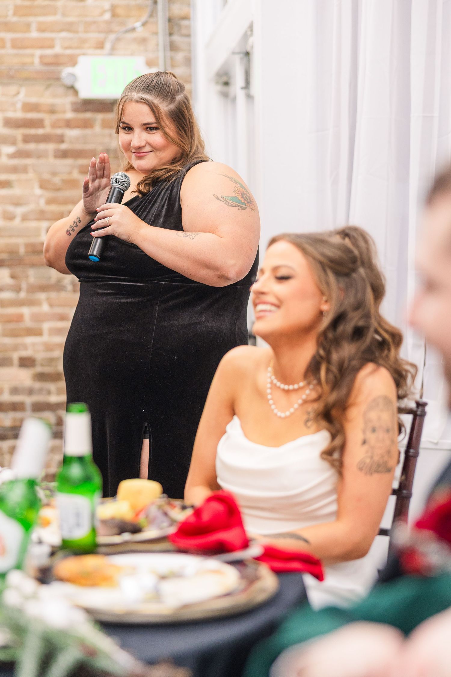 Wedding party members give toasts during an intimate reception with exposed brick walls wedding groom bride wilmington North Carolina