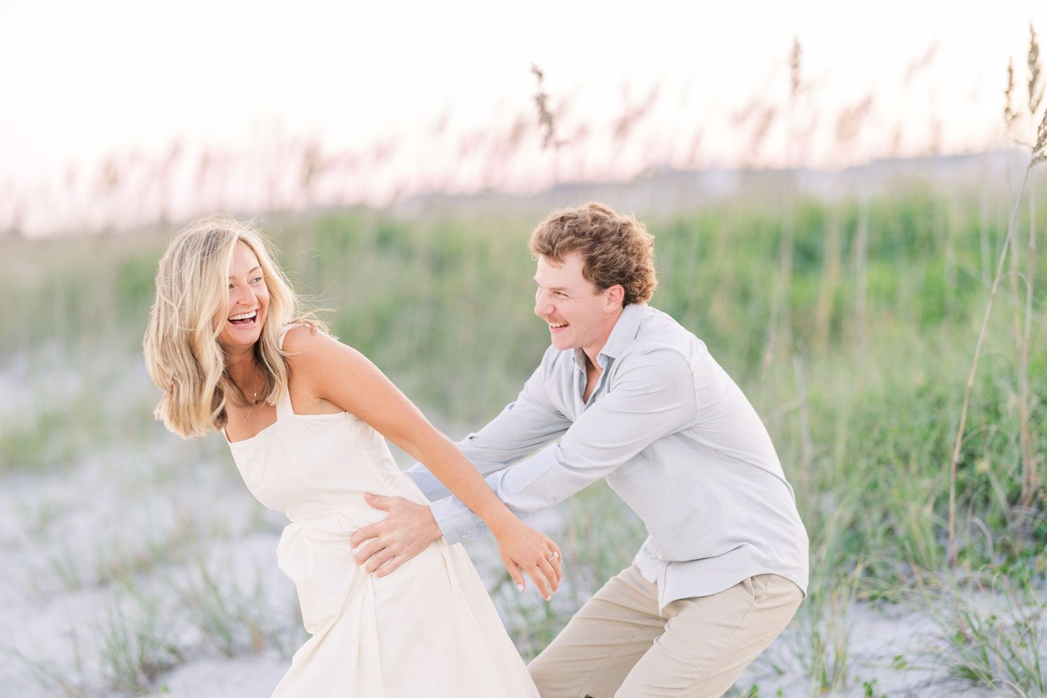 Couple enjoying romantic moment together on sandy beach during sunset.