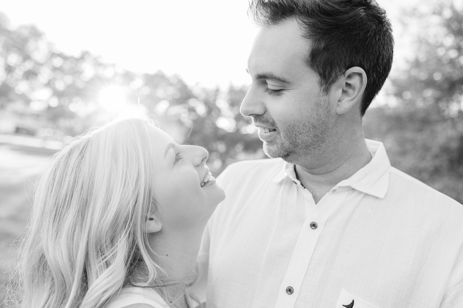 Black and white portrait of a couple sharing tender moments outdoors.