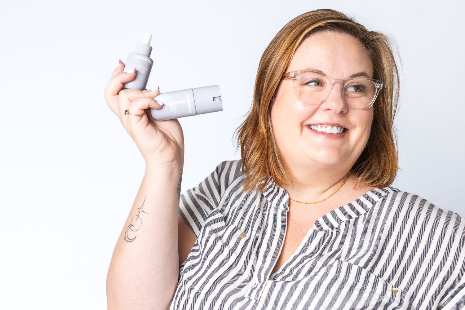 Person in striped shirt displaying various beauty products.