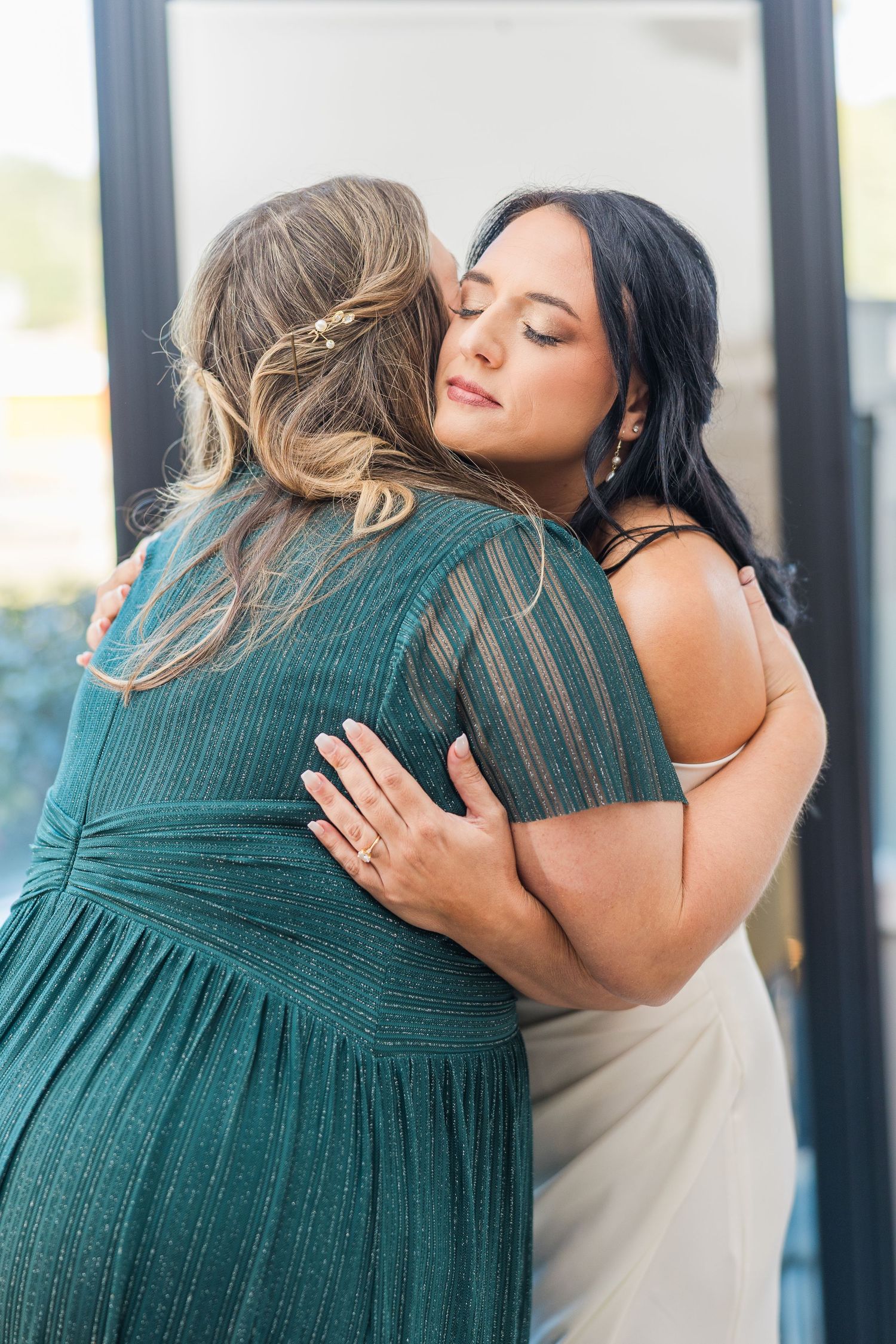 Two people embrace, one wearing a white dress and another in a teal outfit wedding groom bride lake Gaston photographer light airy