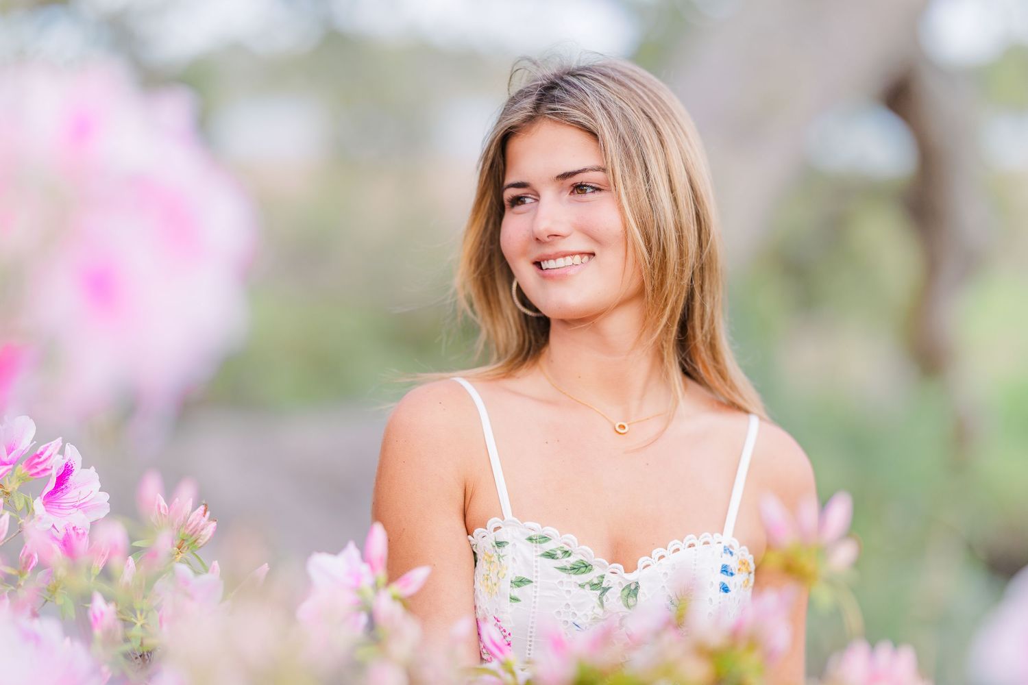 Spring fashion photo shoot with pink blossoms and floral dress.