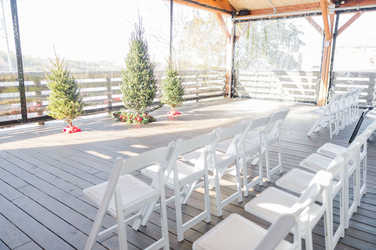 Rows of white folding chairs arranged on a wooden deck for an outdoor ceremony wedding groom bride wilmington North Carolina photographer