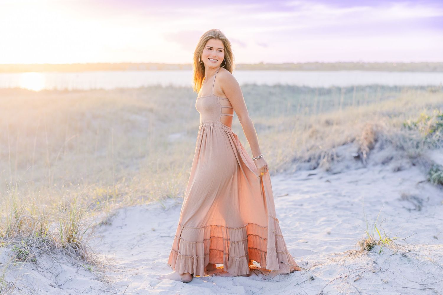 Ethereal beach portrait session with soft lighting and sandy dunes creating a romantic coastal atmosphere.
