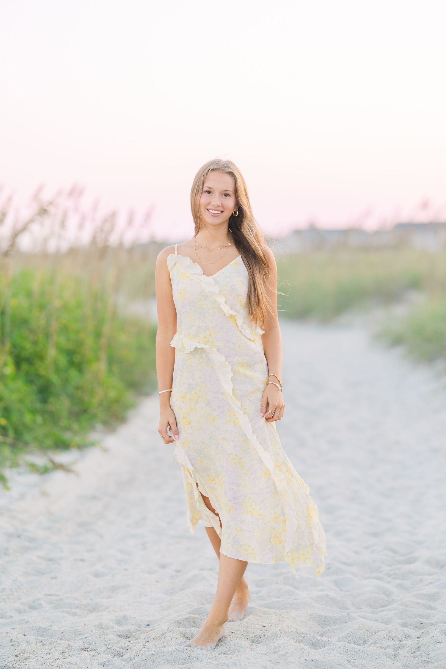 Dreamy beach photoshoot in a flowing yellow sundress at sunset.
