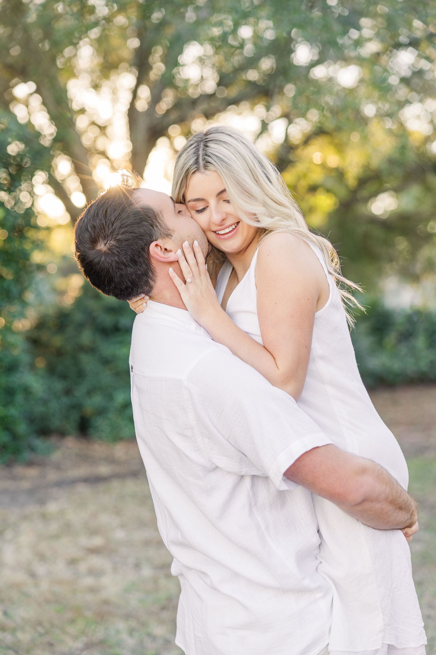 Joyful couple sharing intimate moments and laughter during an outdoor photoshoot.