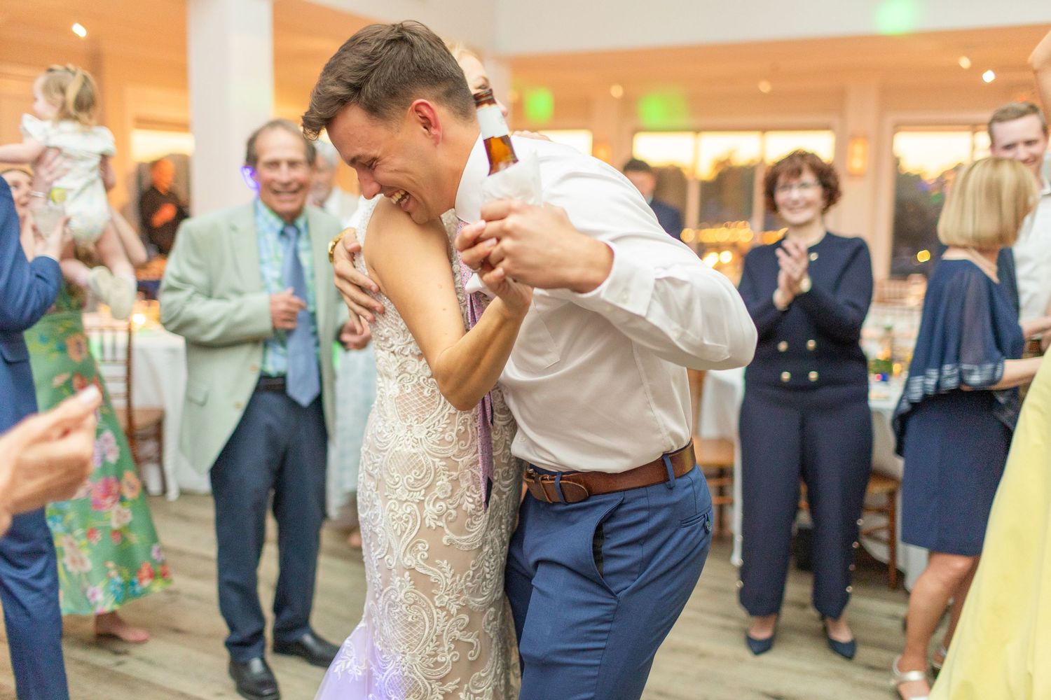A romantic dance dip during a wedding celebration with guests watching in the background.