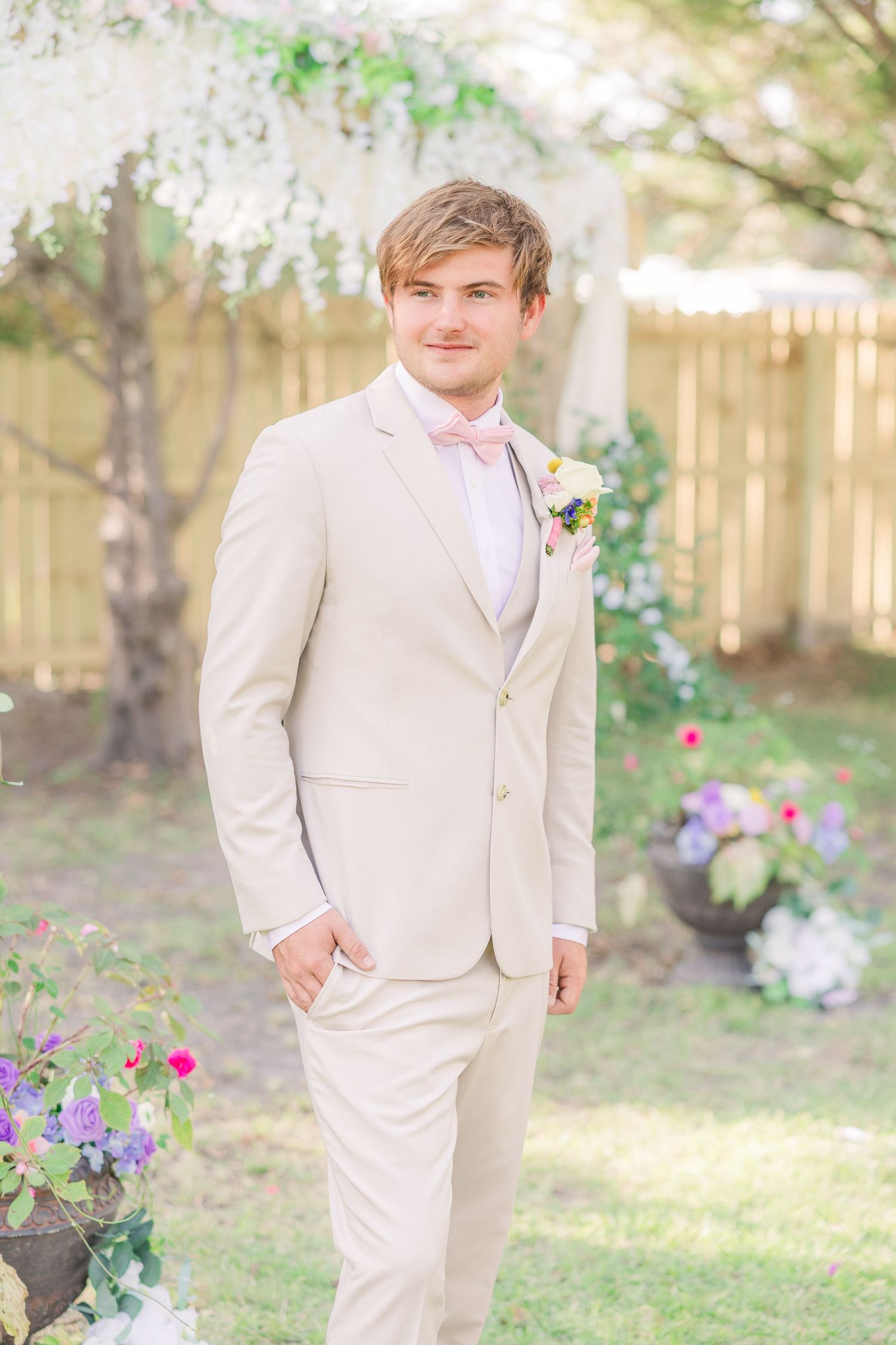 A groom in a beige suit and pink bow tie wedding groom bride wilmington photographer light and airy classic Wrightsville Beach