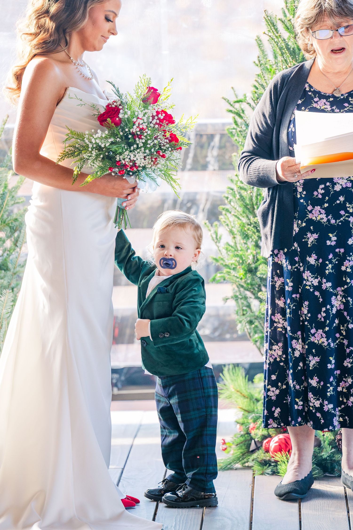 Wedding party posing with red bouquets and formal attire in an outdoor setting wedding groom bride wilmington North Carolina photographer