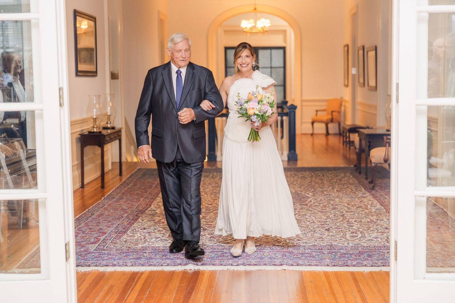Elegant hallway with warm lighting and arched doorways in a wedding venue.