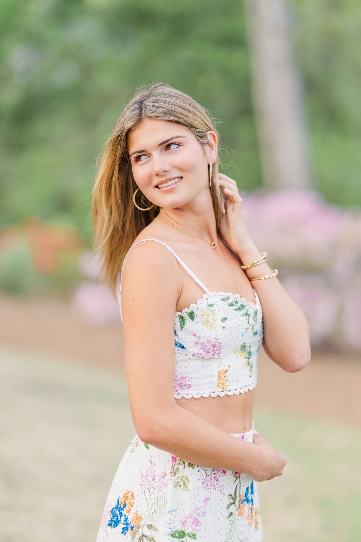 Summer portrait session in a garden with flowering plants and natural greenery.
