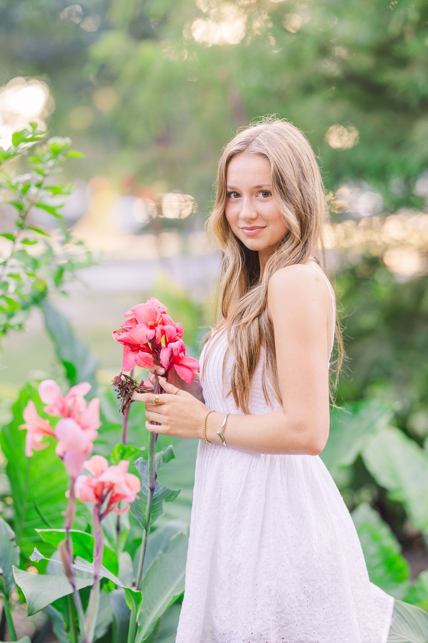 A summer photoshoot in a garden with pink flowers and soft natural lighting.