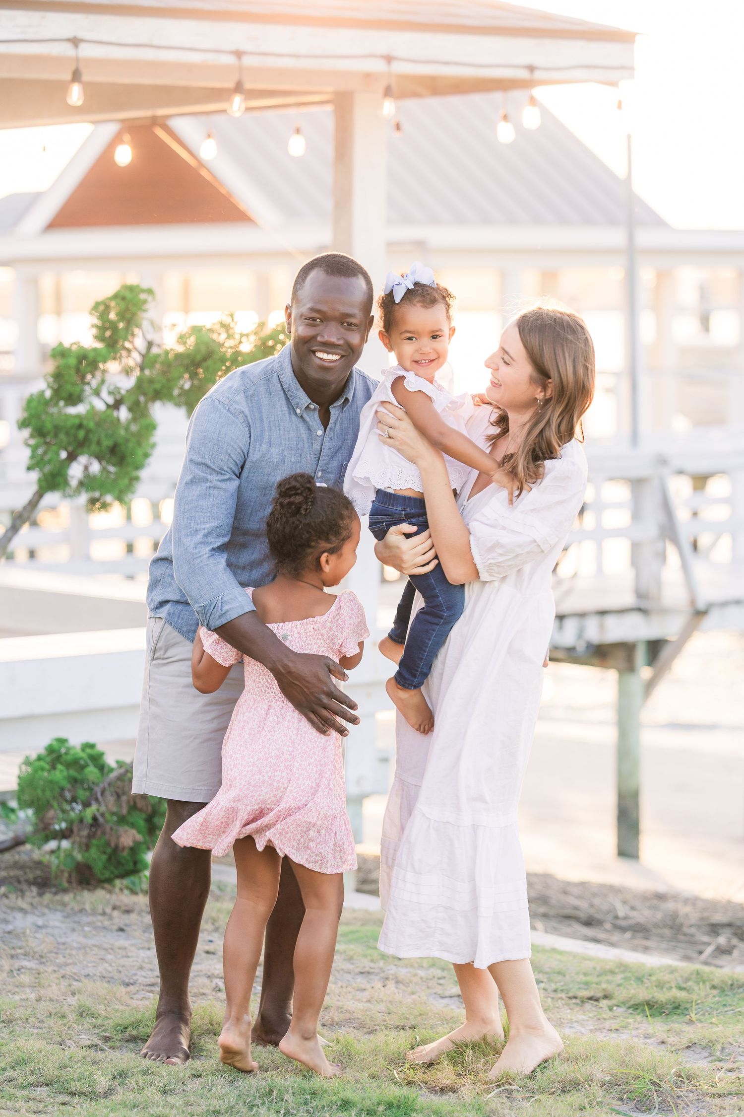 Family embracing and sharing tender moments during beachside photoshoot.