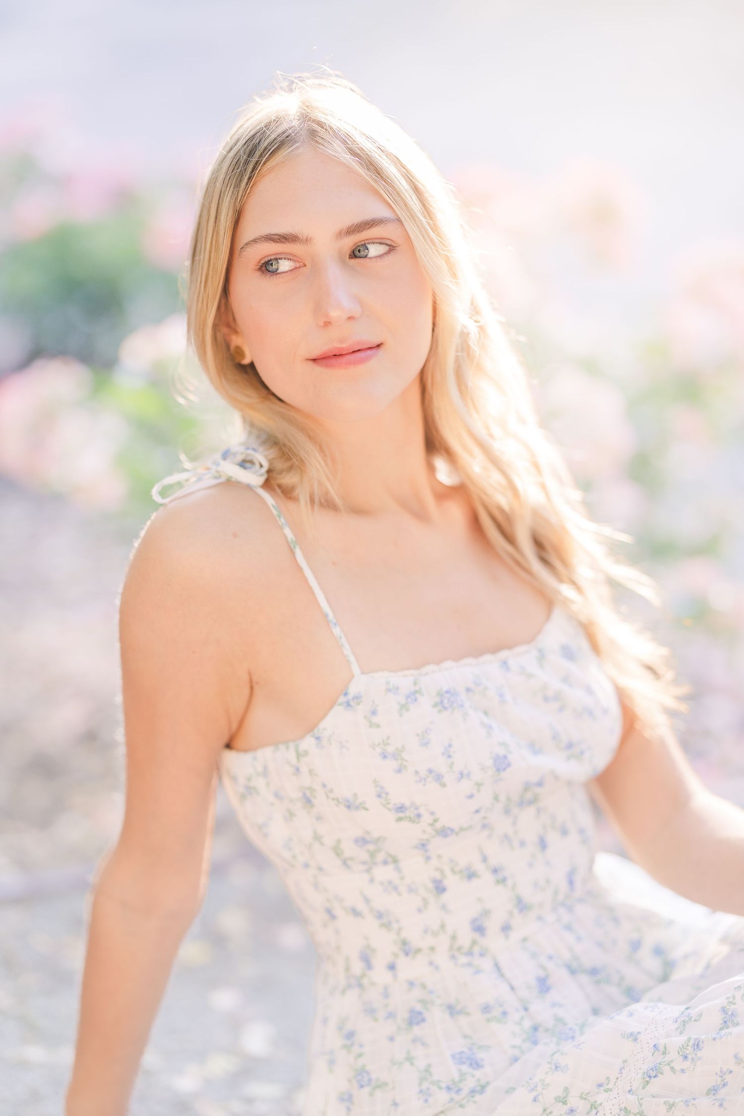 Ethereal summer portrait in soft lighting wearing a delicate floral dress.