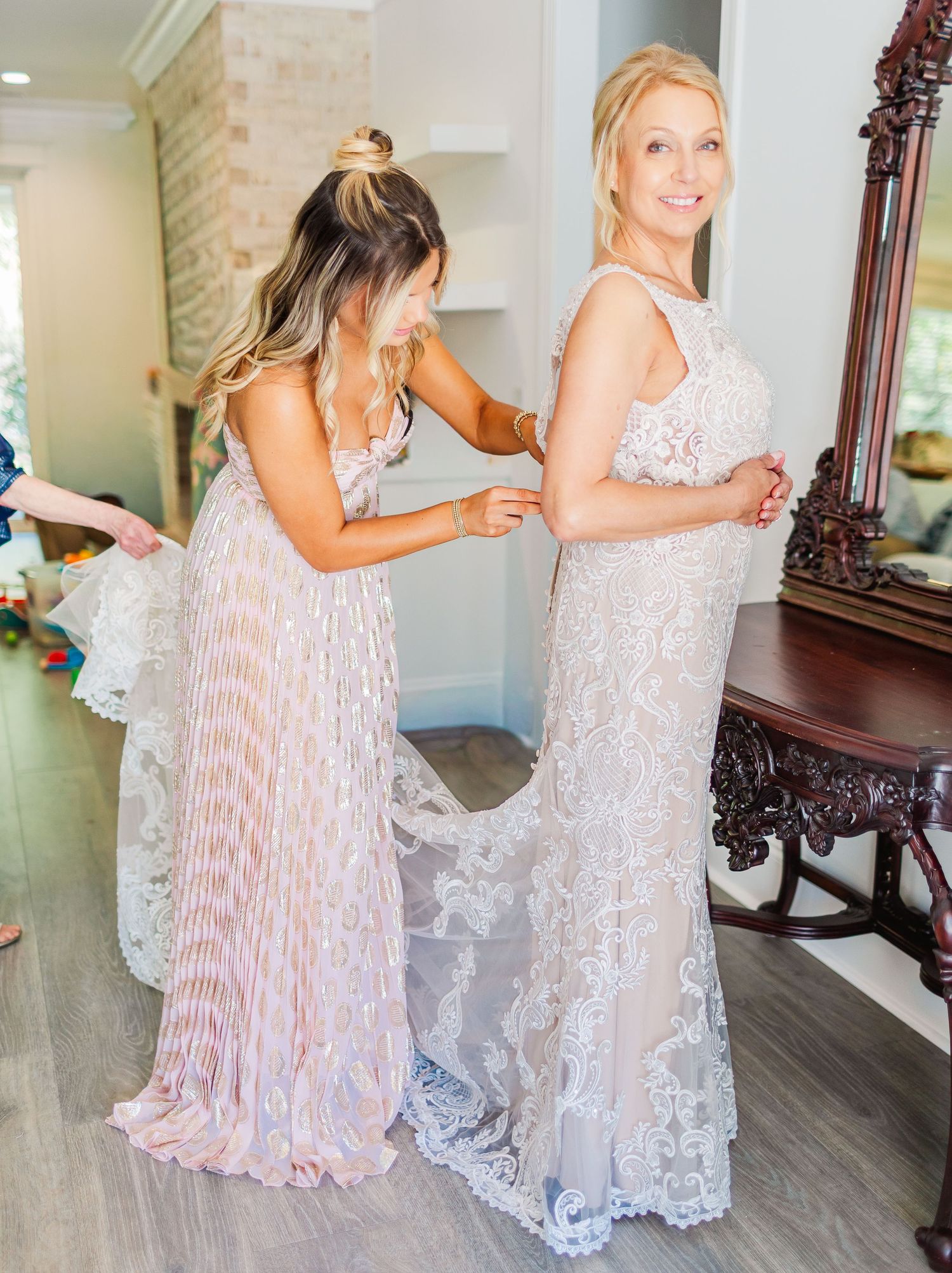 Wedding preparation scene with flowing white lace dress and pink accents.