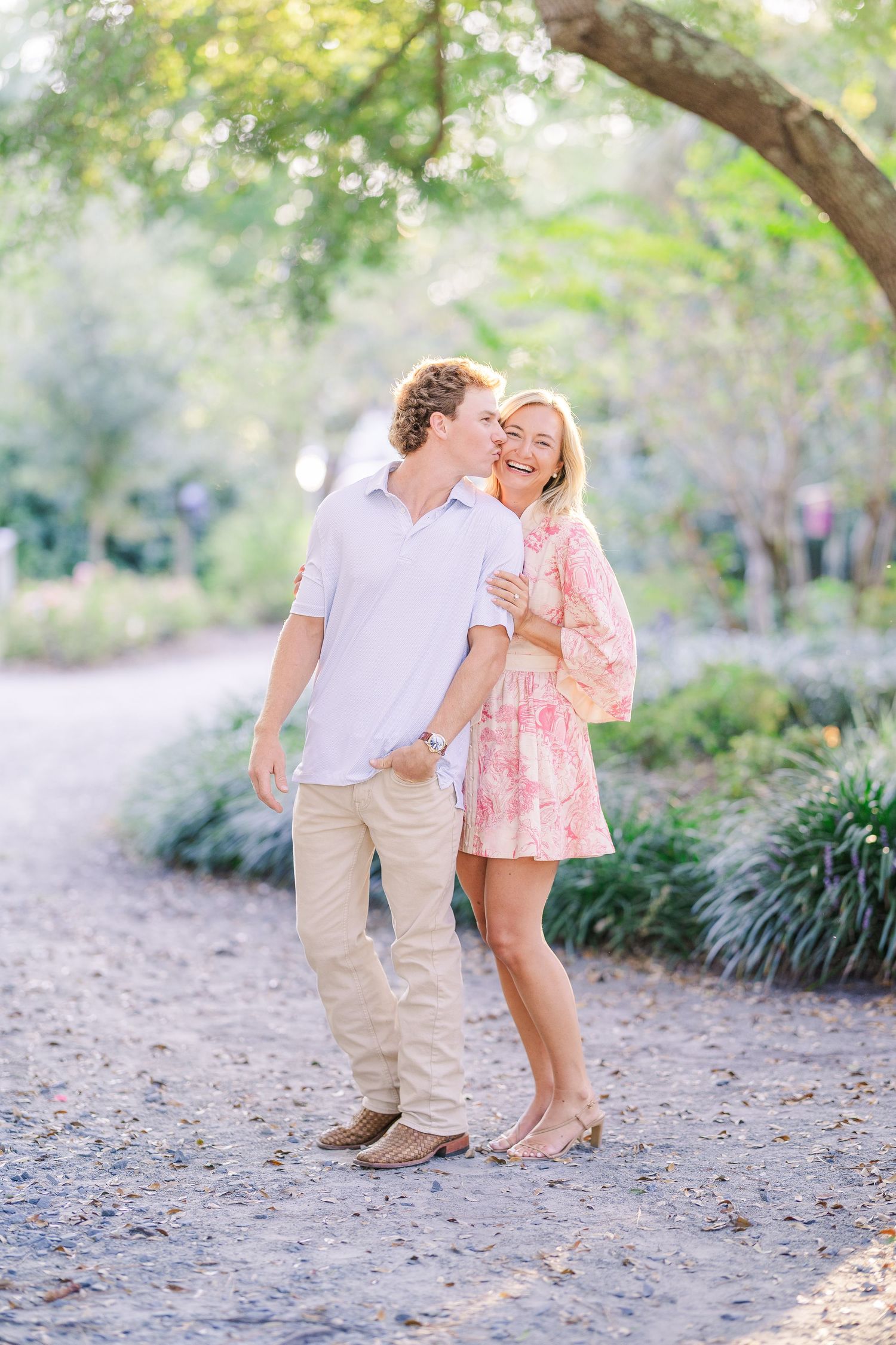 Candid interaction between two people on a garden trail with natural lighting.