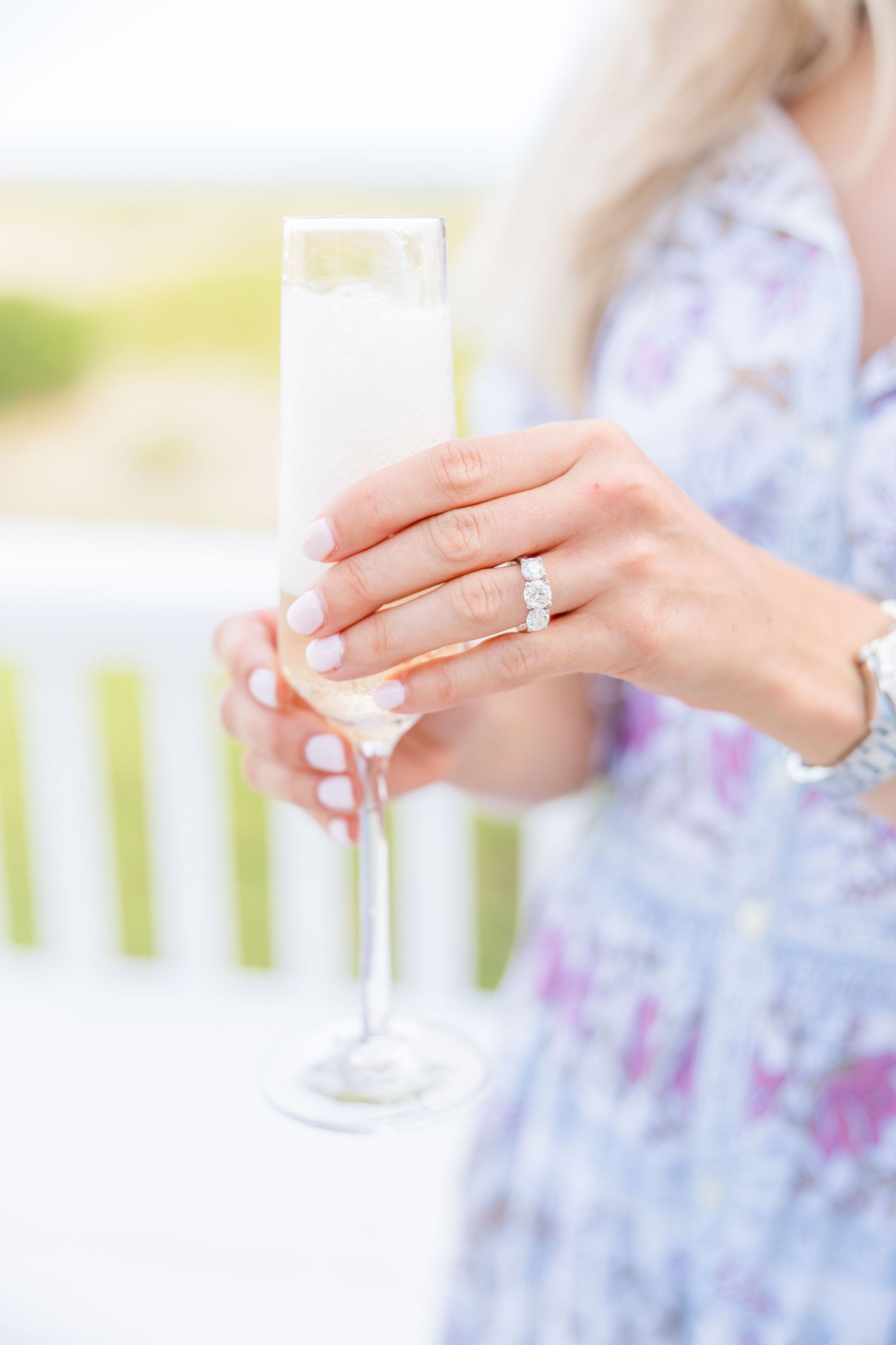 Close-up of hands holding champagne glasses during an outdoor celebration.