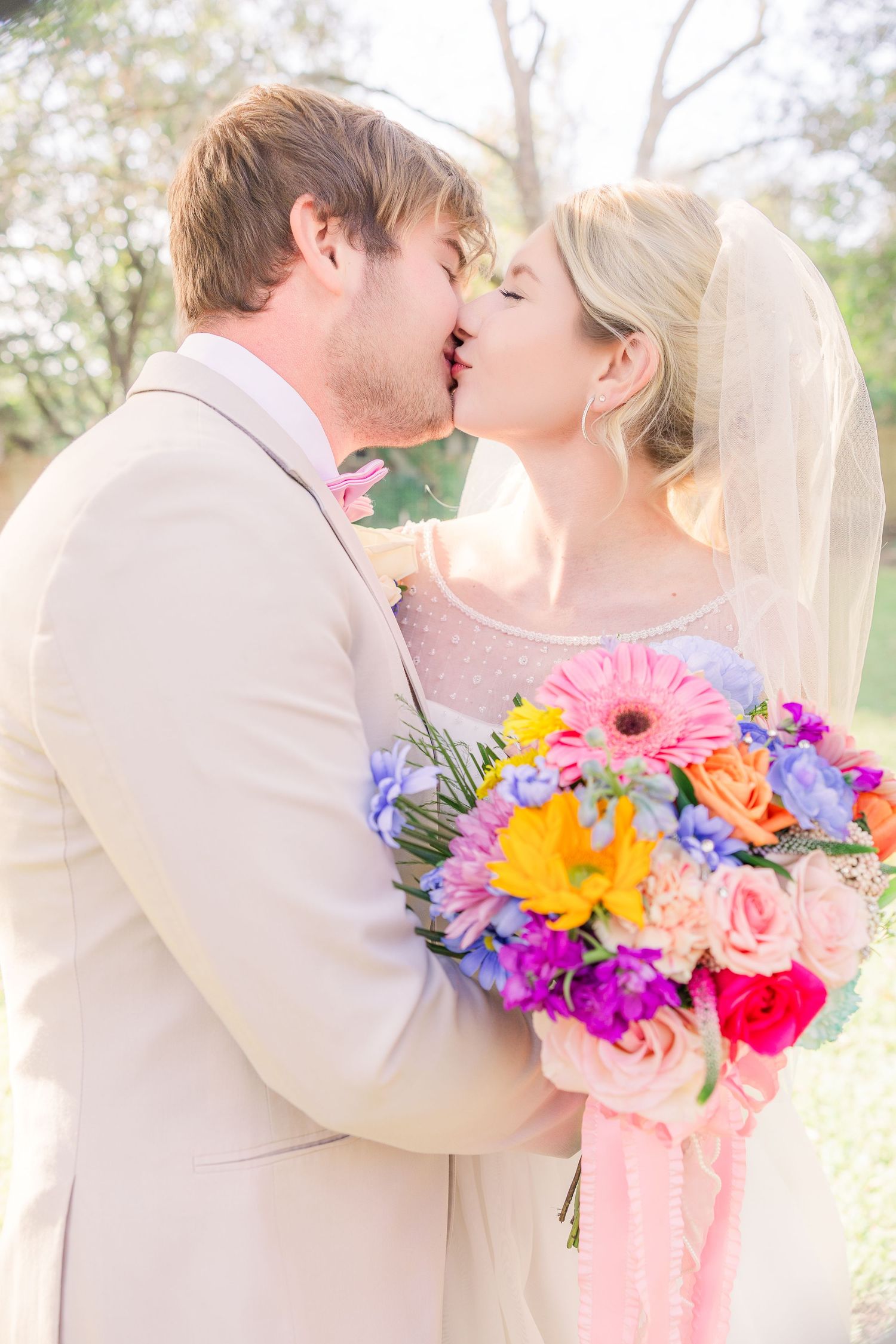 Wedding couple embraces with colorful floral bouquet wedding groom bride wilmington photographer light and airy classic Wrightsville Beach