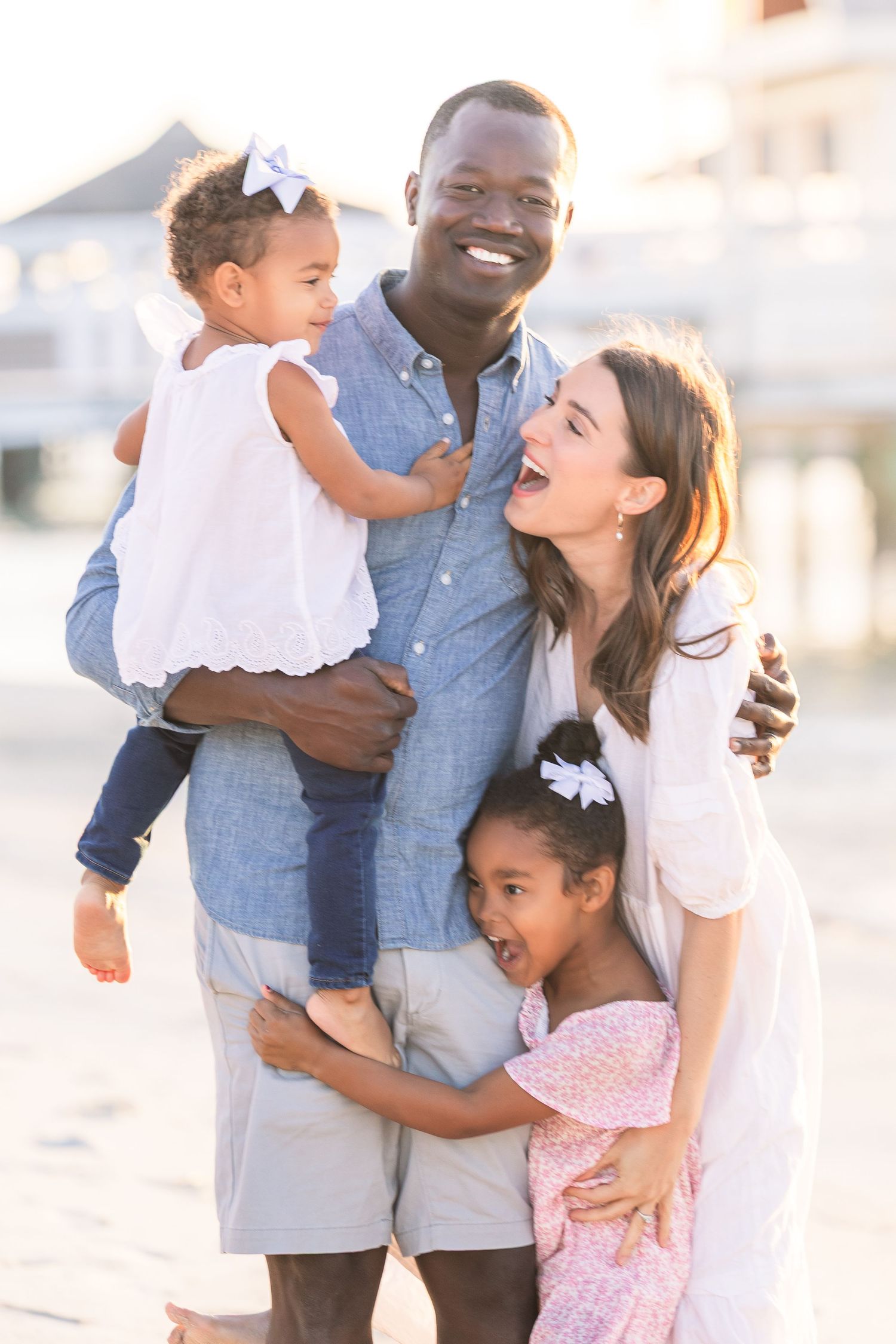 Intimate family portrait showing natural interactions and laughter at sunset.