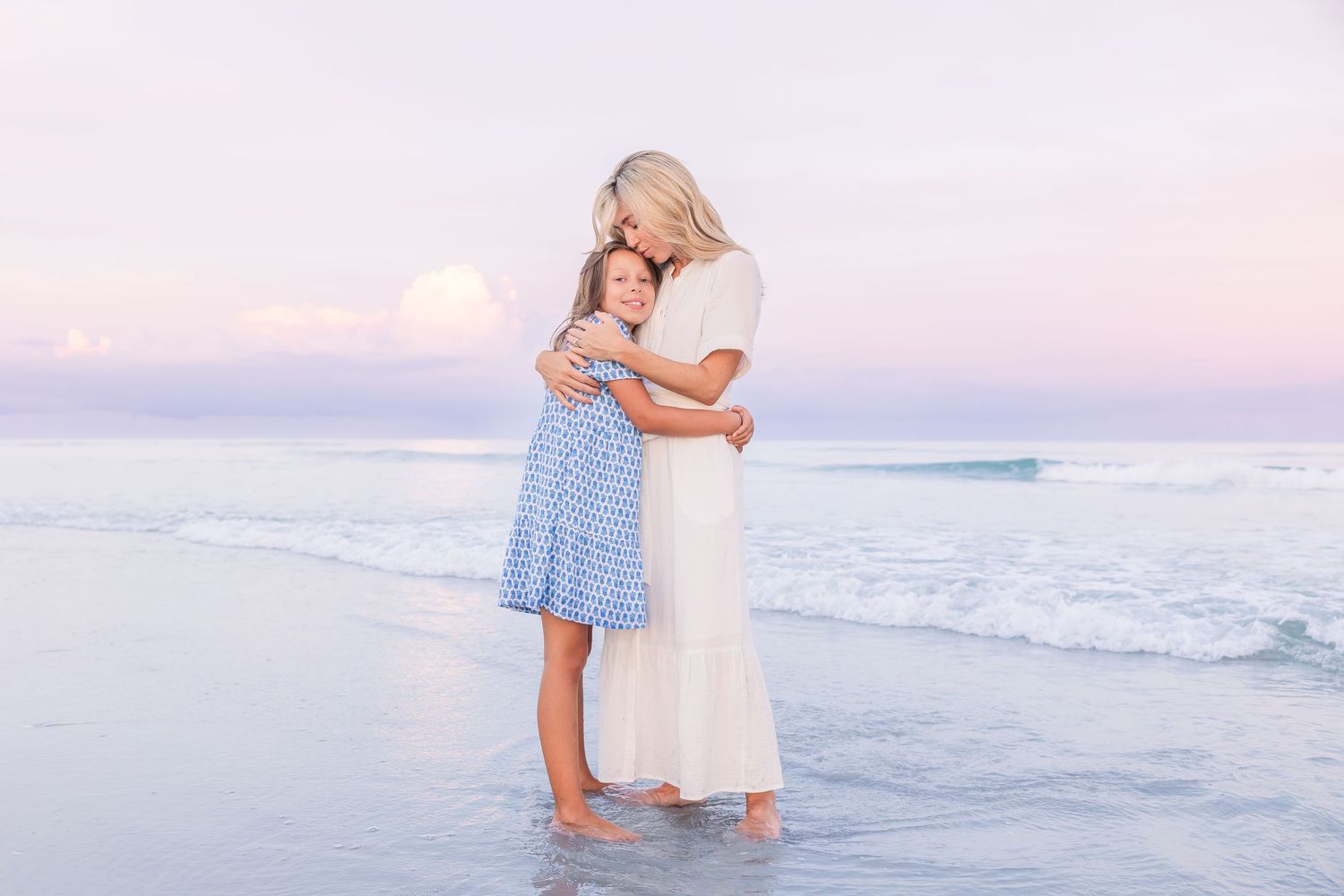 A tender embrace shared between family members during a beach sunset photoshoot.