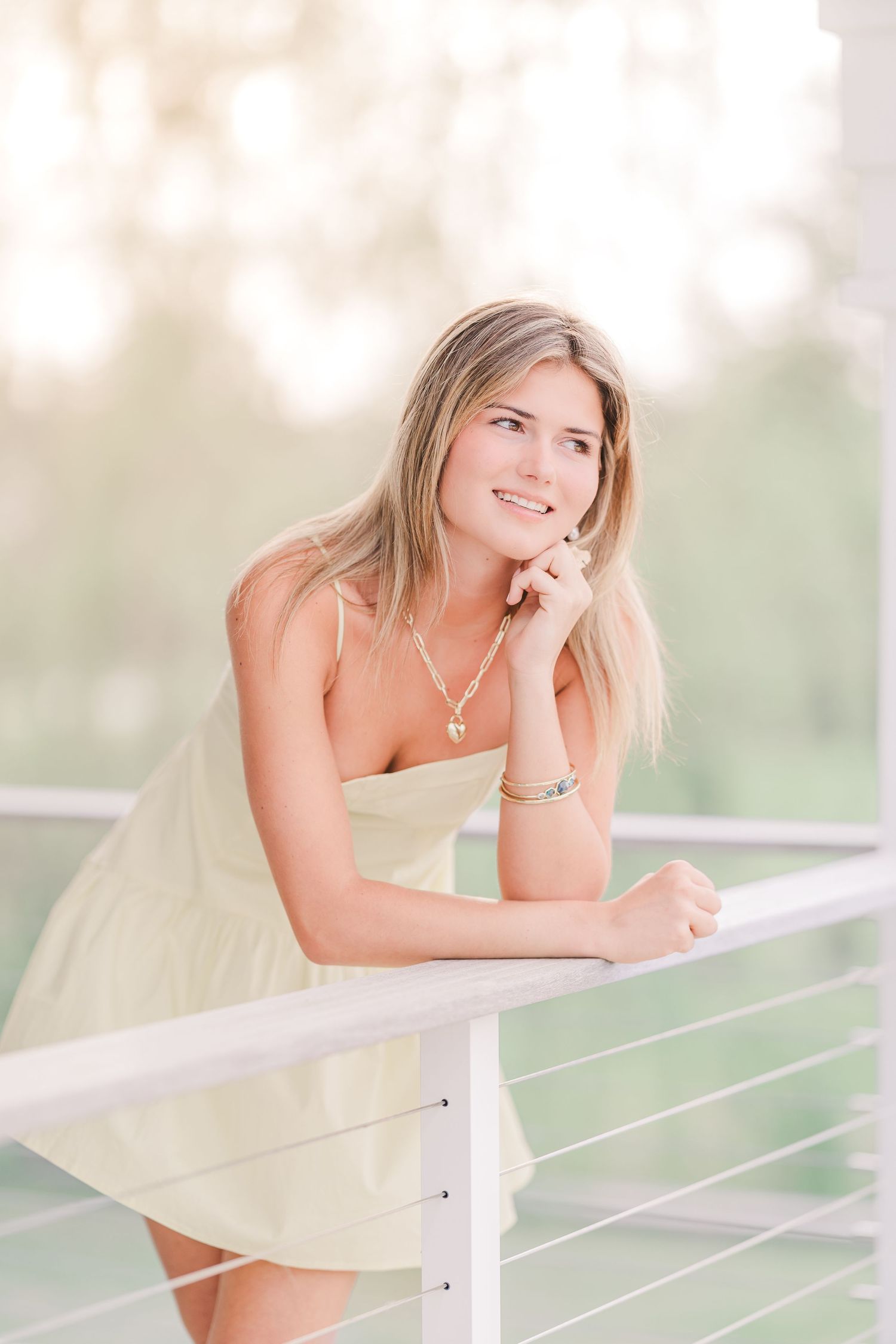 Casual portrait session on a modern deck with white railings and soft natural lighting.